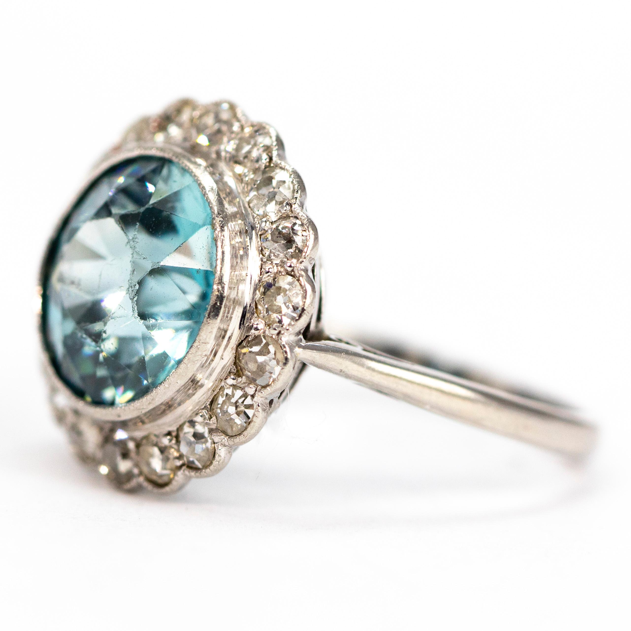 The gorgeous blue of this zircon is perfectly complimented by the halo of sparkling diamonds surrounding it. The zircon measures approximately 5carat and the diamonds measure 4pts each. 

Ring Size: N or 6 3/4 
Cluster Diameter: 16mm 

Weight: 6.05g