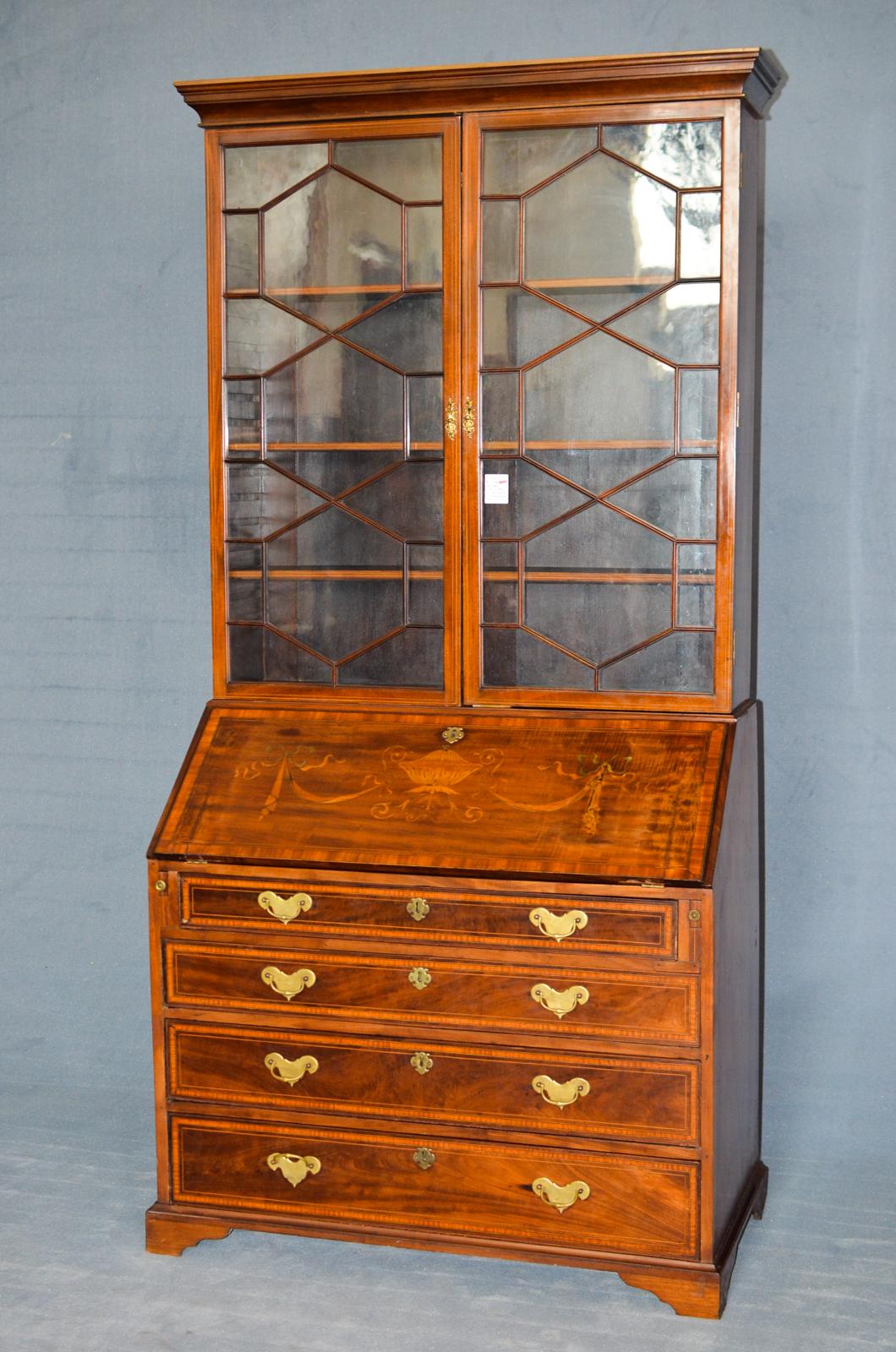 Edwardian bookcase in inlaid mahogany from the United Kingdom and dated 1895. It has a window in the upper part and a Secretaire in the lower part with various internal drawers and four large lower drawers. It has some signs of wear but is in good