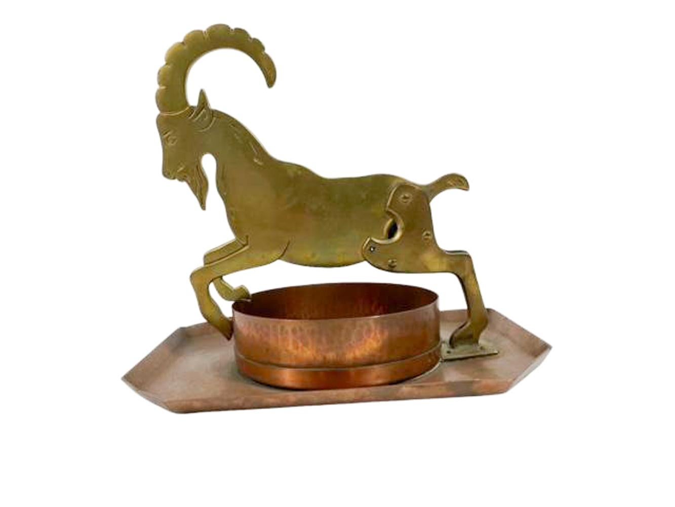 Arts and Crafts figural metalwork cigar cutter / ashtray. A brass Billy goat cigar cutter, jointed at the hip with integral cutter leaping over a cylindrical copper receptacle mounted on an elongated octagonal tray. The tray marked on the underside