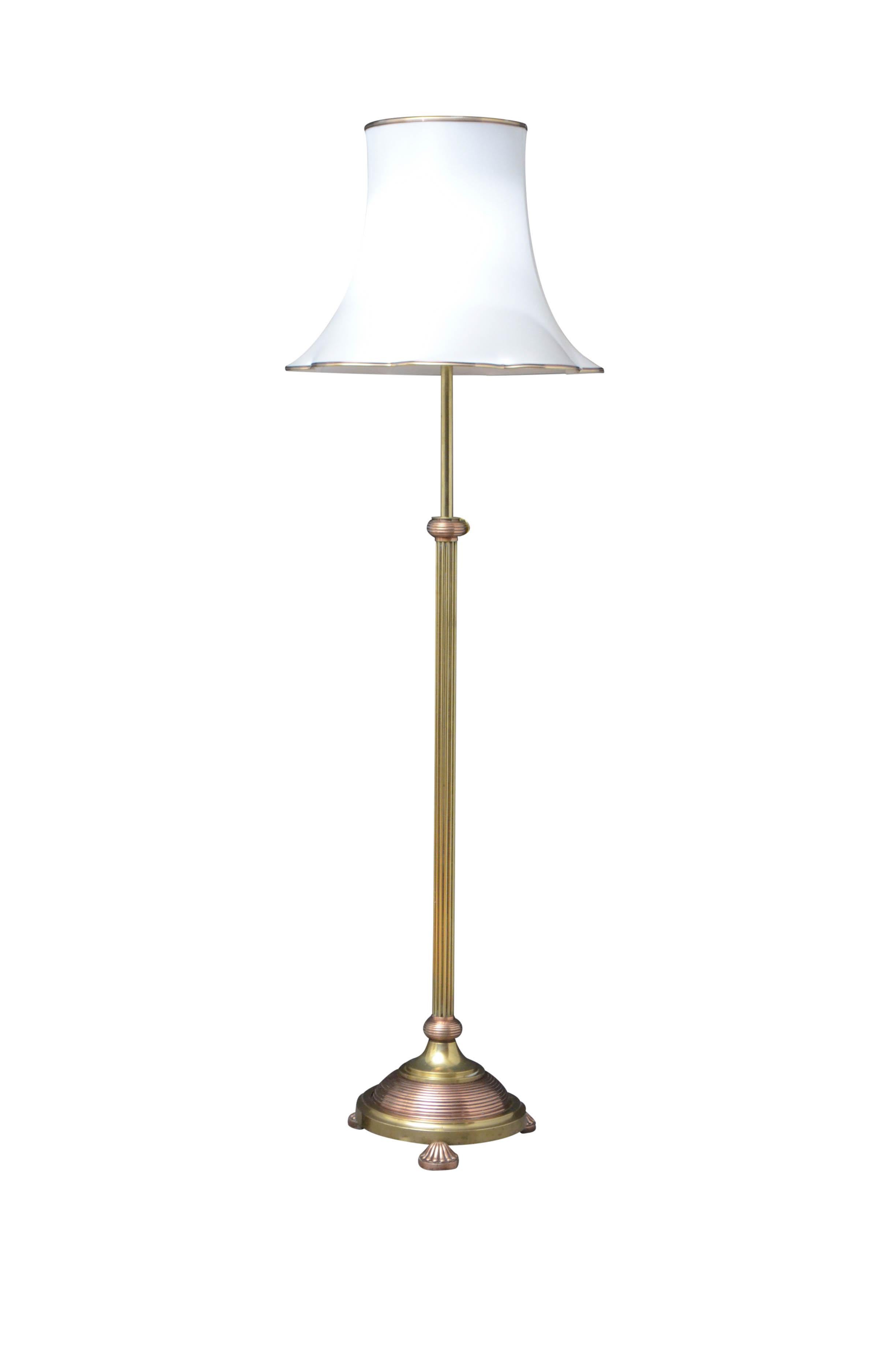 Elegant Edwardian height adjustable standard lamp with brass reeded column terminating in circular copper base and fluted pad feet in copper. This antique lamp has been cleaned and polished, professionally rewired and pat tested, all in home ready