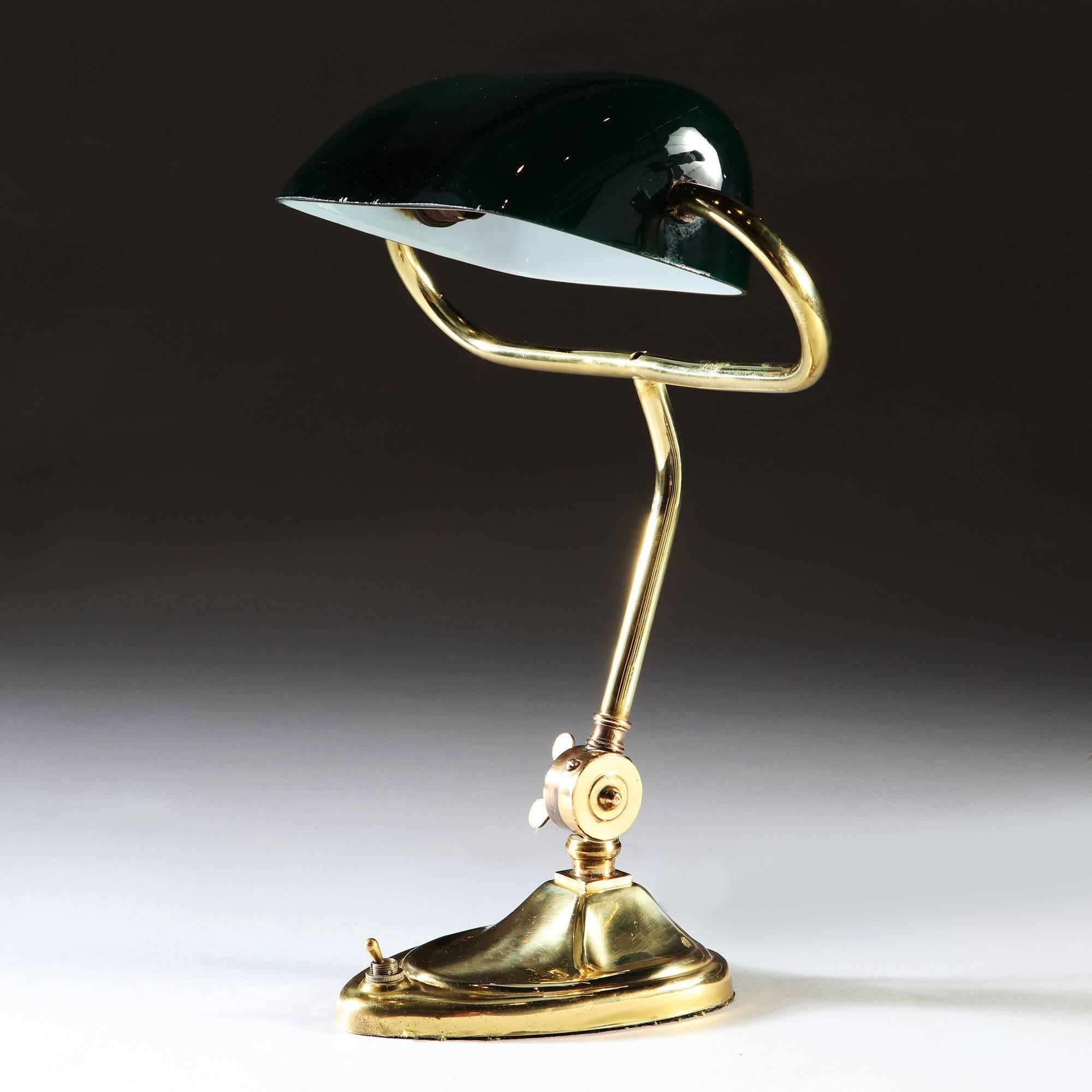 An Edward brass desk lamp with adjustable green glass shade and a heart shaped base.