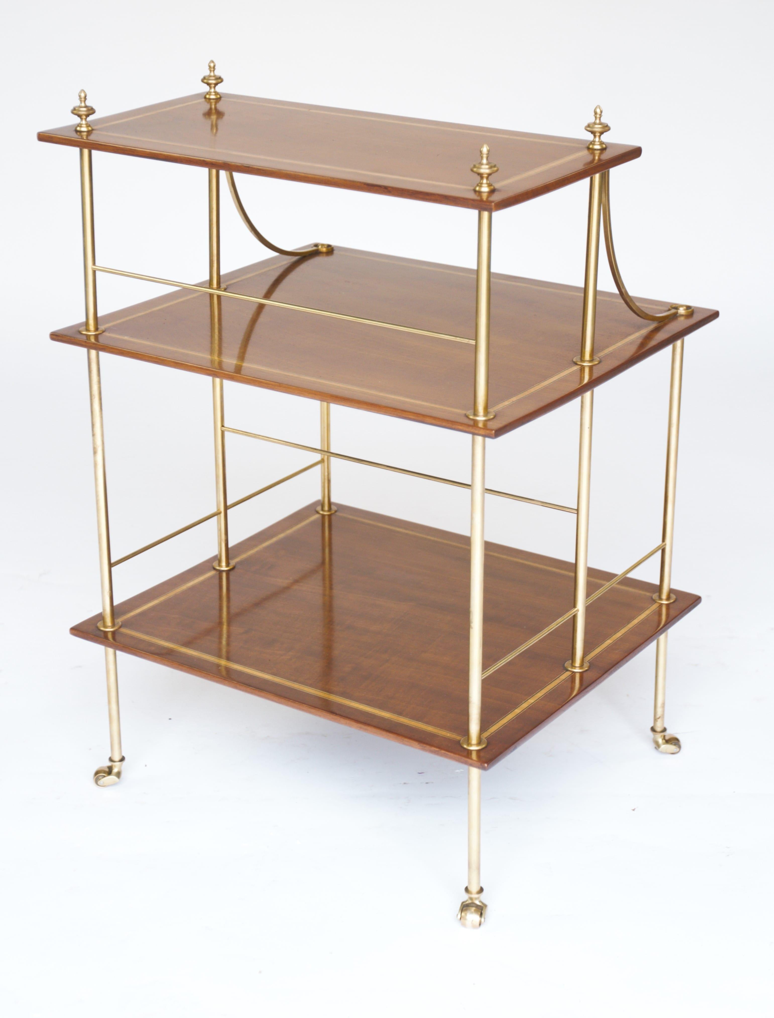 Etagère Edouardienne à 3 niveaux en laiton et acajou incrusté
3 étagères en acajou et satiné marquetées, 
Supporté par un cadre à colonne en laiton 
avec épis de faîtage au sommet, 
Assis sur des roulettes en laiton
Récemment polie