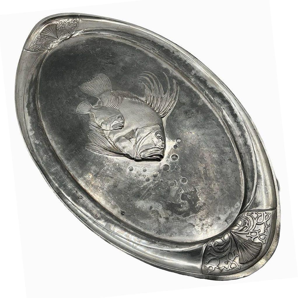 Esta bandeja de la WMF (Württembergische Metallwarenfabrik), que data aproximadamente de 1900 a 1918, recoge el arte y la calidad primitivos por los que la WMF se hizo famosa. El uso del metal Britannia, poco común por su durabilidad y su rico tono