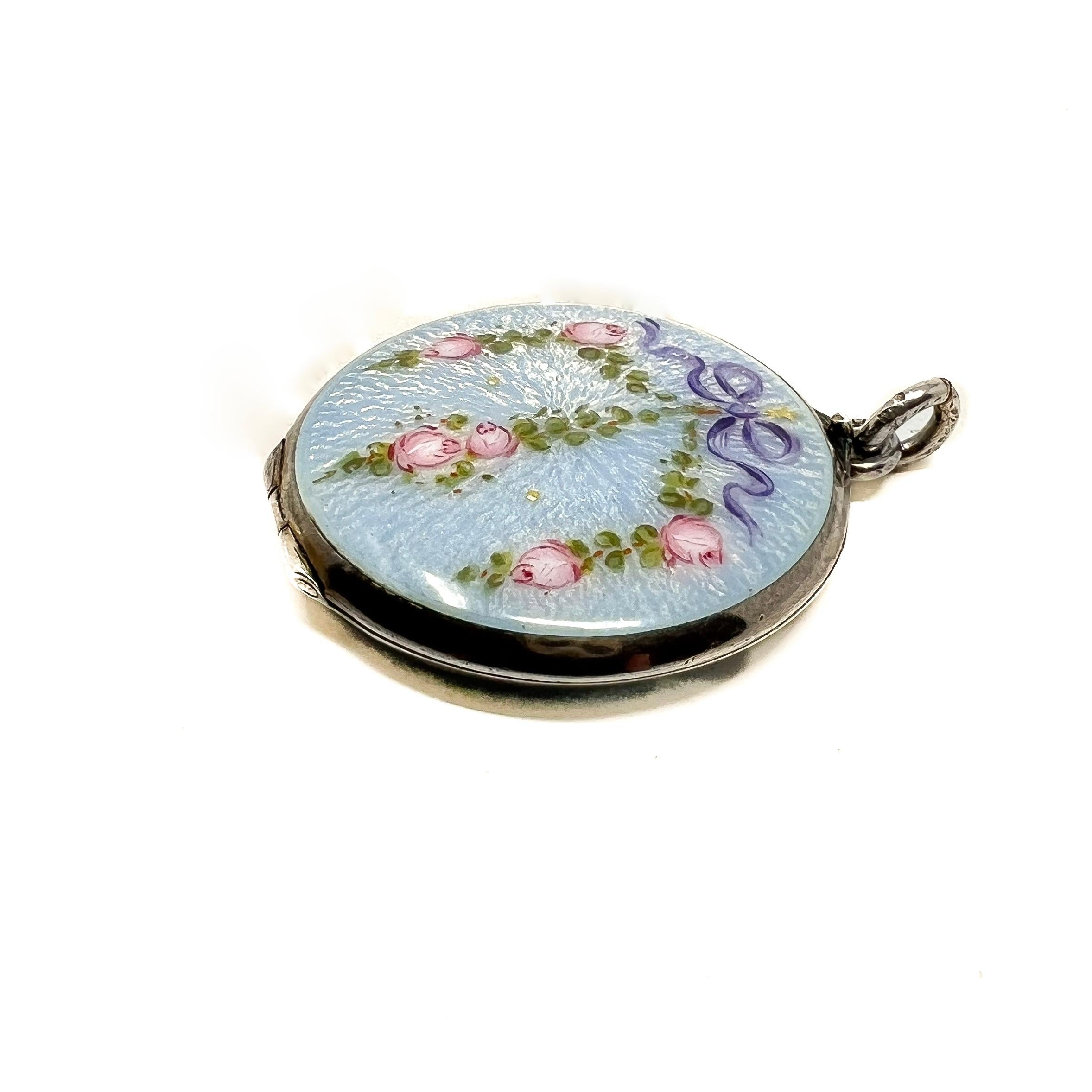 This pretty locket dates from c.1900 and represents the garland style so typical of Edwardian era jewels. 

Condition Report:
Excellent

The Details...
This locket is constructed from silver. It is stamped on the bail with '935'. Although it does