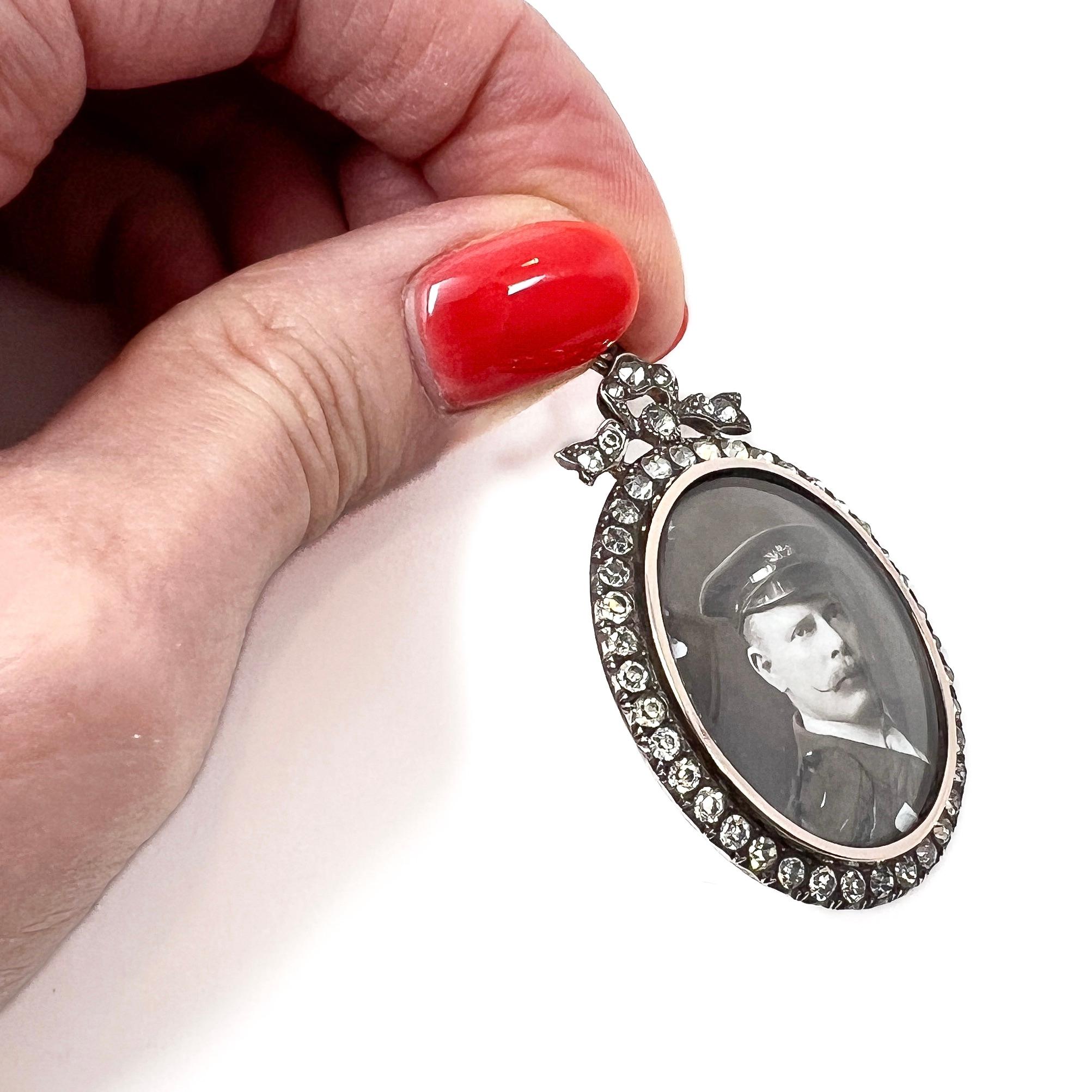 This pretty locket dates from c.1900 and represents the garland style so typical of Edwardian era jewels. 

Condition Report:
Excellent - The locket itself is excellent. However, there is a repair to the enamel photograph of the gentleman.

The