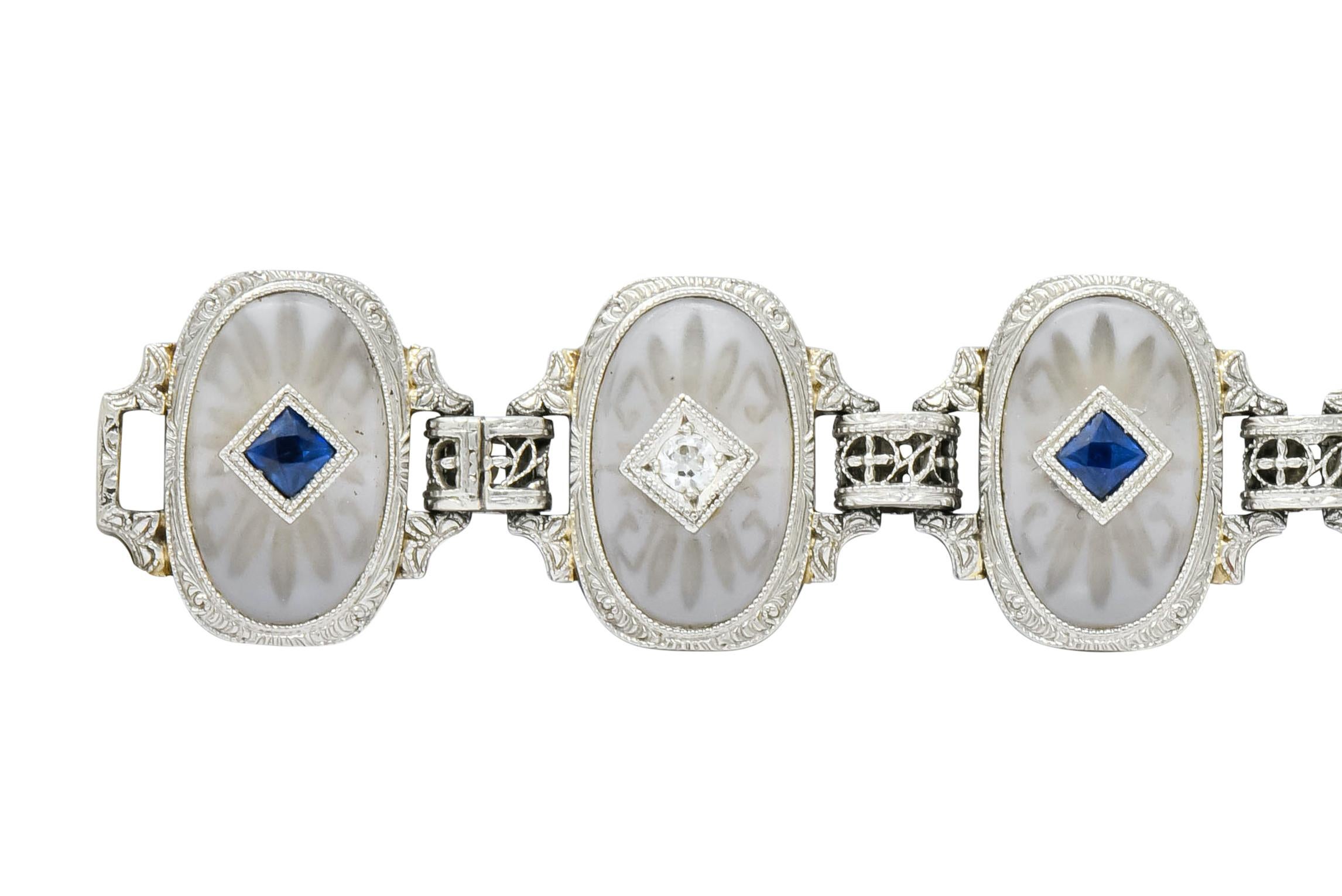 Link style bracelet comprised of deeply carved oval camphor glass, bezel set in a delicately engraved millegrain surround, each centering either a French cut sapphire or a transitional cut diamond

Diamonds weigh approximately 0.31 carat, eye-clean