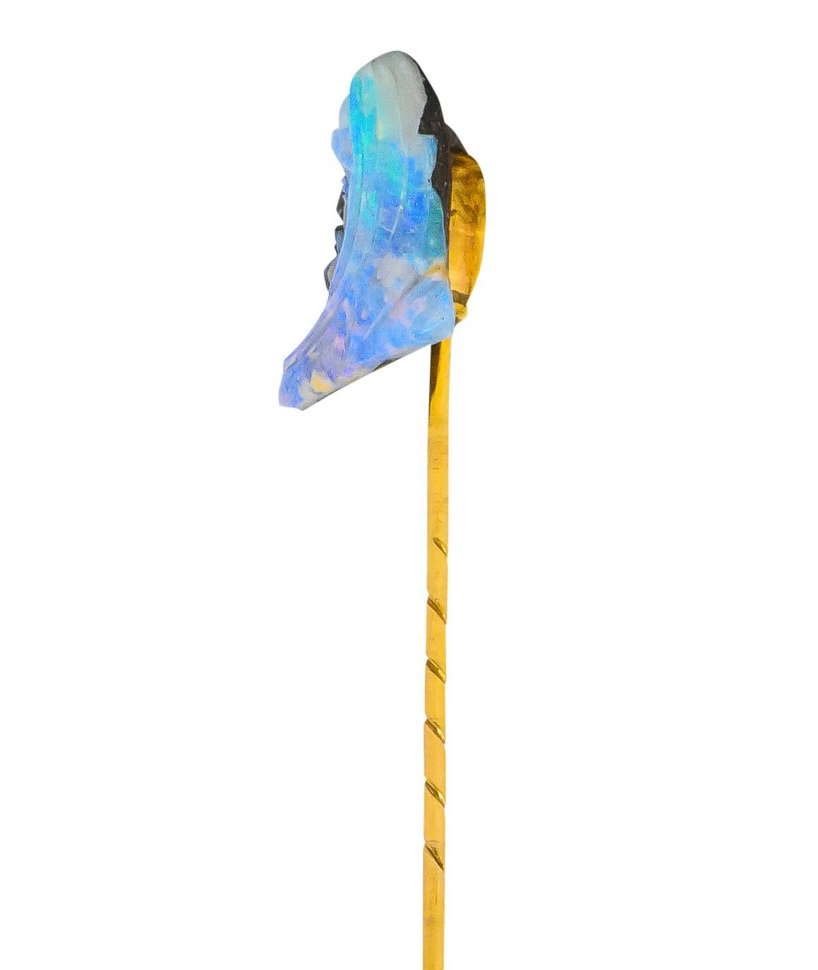 Centering a deeply carved boulder opal depicting the profile of a man with a stylized beard and a long, flowing cloth headdress

Featuring broad flashes of blue/violet spectral play-of-color 

Accented by dark brown matrix speckled with white along