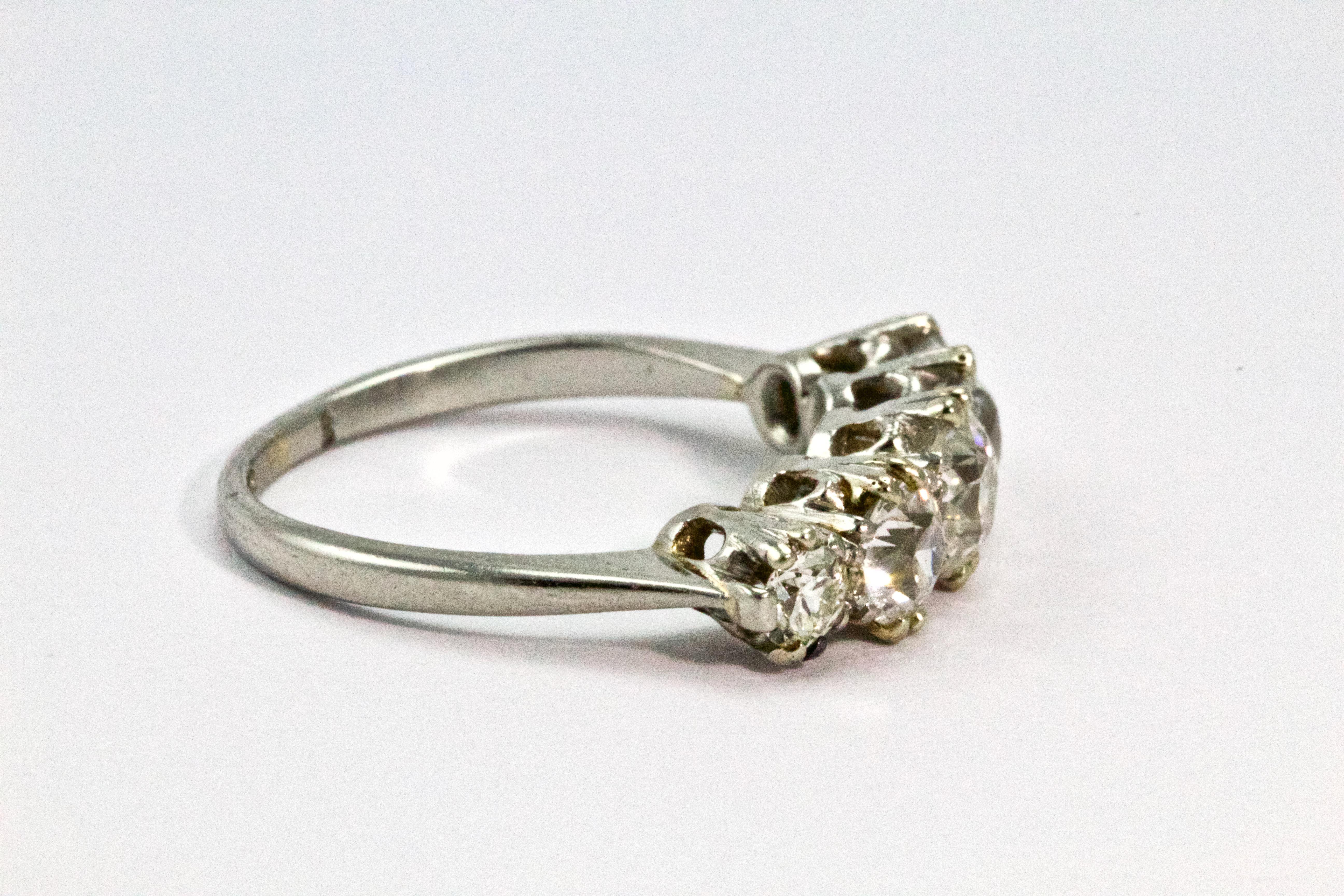 This antique Edwardian diamond and platinum ring was handcrafted in England around 1910. This glimmering ring features five Old European cut diamonds weighing certified 1.6 carats, H/I colour and VS1 clarity. These diamonds are graduated, lined in a