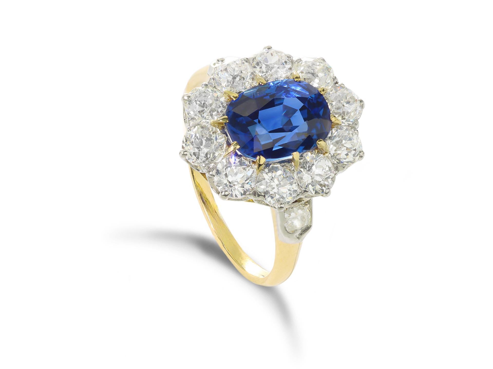 Edwardian Ceylon sapphire and diamond coronet cluster ring. Set to centre with an oval old cut natural unenhanced Ceylon sapphire in an open back claw setting with an approximate weight of 3.40 carats, surrounded by ten round old cut diamonds in