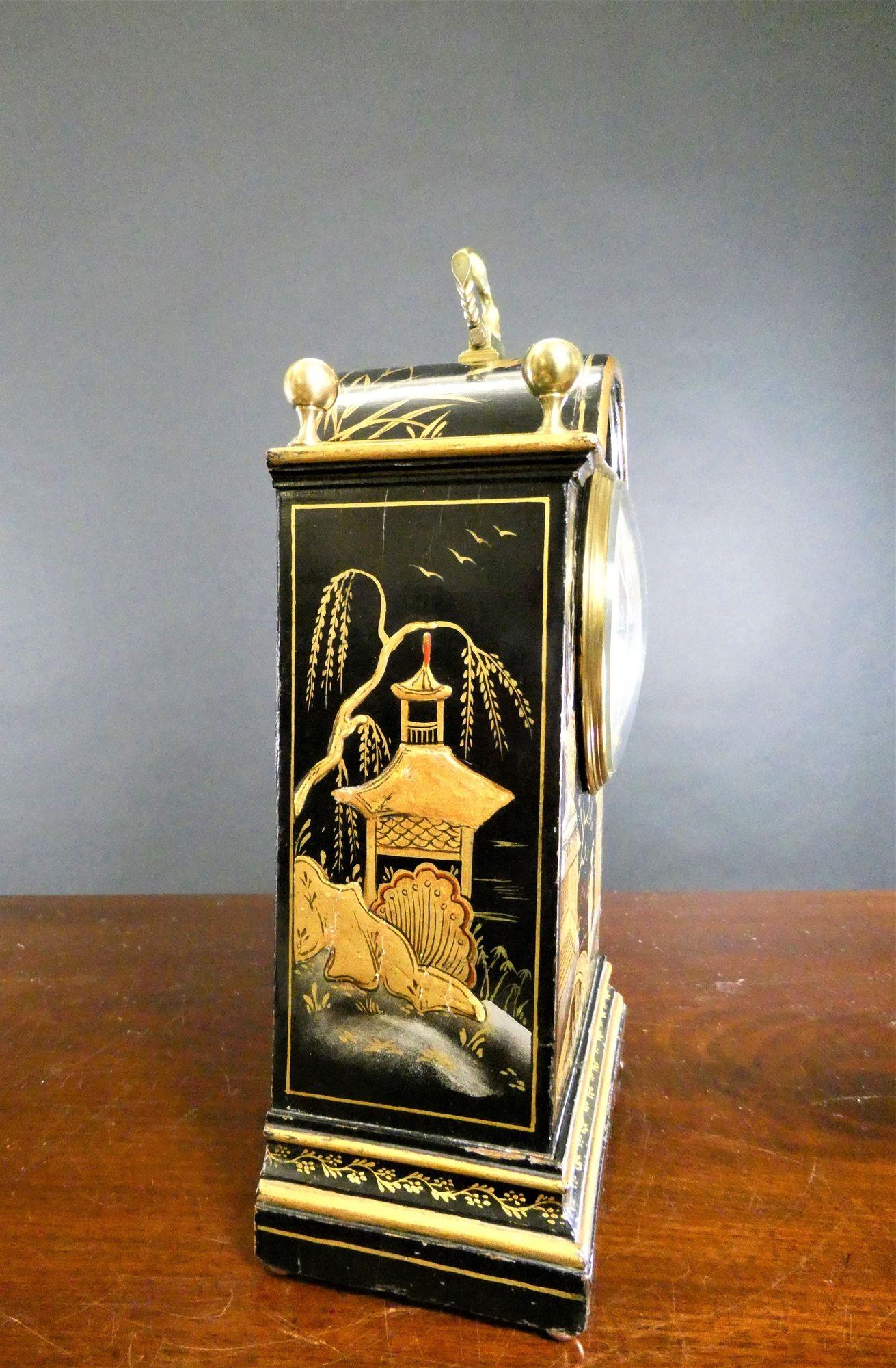 Edwardian Chinoiserie Decorated Mantel Clock, John Bagshaw & Sons, Liverpool
Break arch case with raised chinoiserie scenes on an ebonised ground, four brass finials and decorated carrying hinged handle, raised stepped plinth resting on four brass
