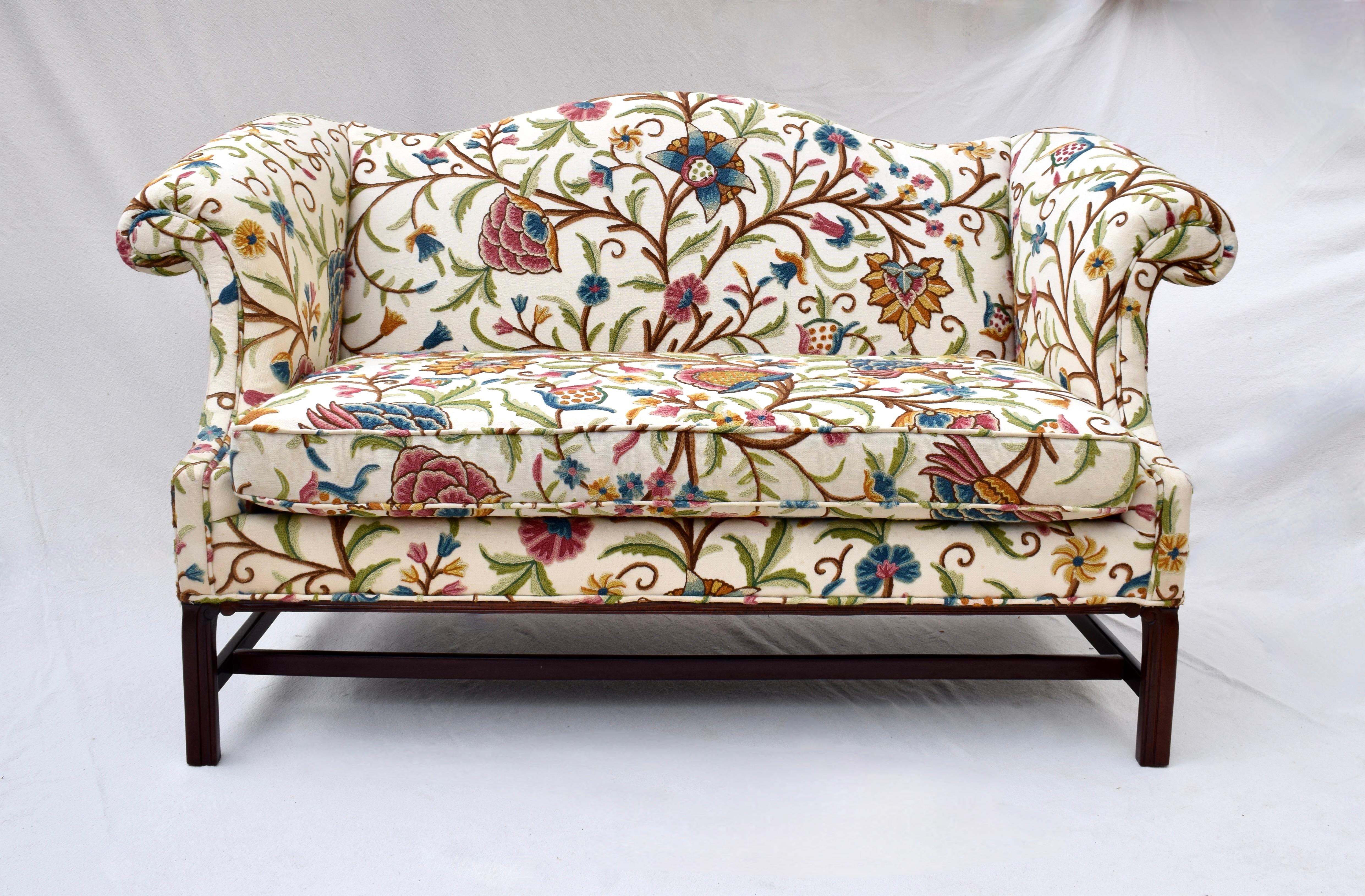 Edwardian camel back Chippendale style loveseat sofa in original English Crewel embroidered upholstery. An extremely comfortable loveseat boasting heirloom quality typical of Hancock & Moore Furniture. Original tags are in tact. Seat: 19