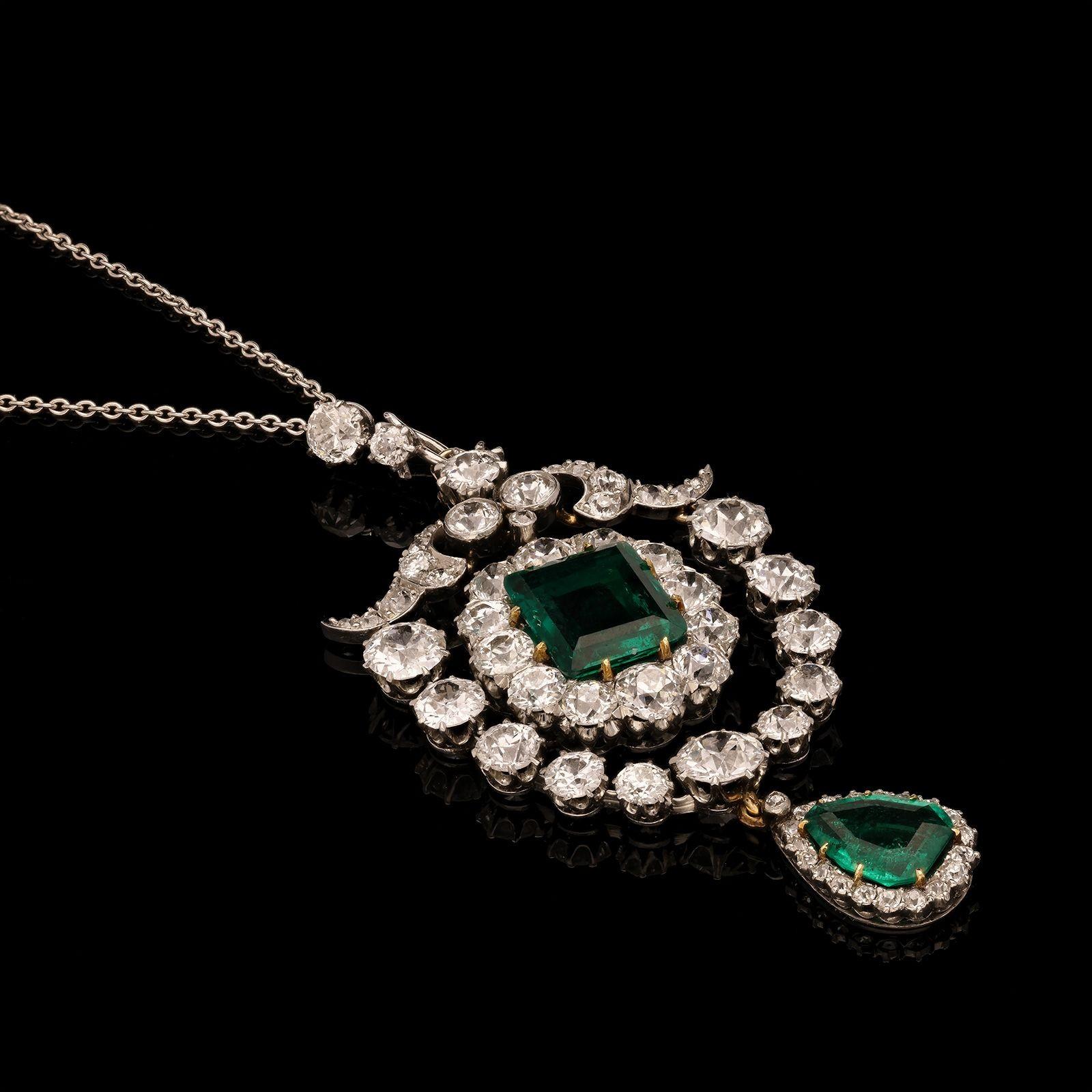 A stunning Edwardian diamond and emerald pendant c.1910, the pendant centred on a rectangular Colombian emerald weighing 2.10cts with a cluster surround of old-cut diamonds, suspended within an outer frame of graduated old-cut diamonds with a scroll