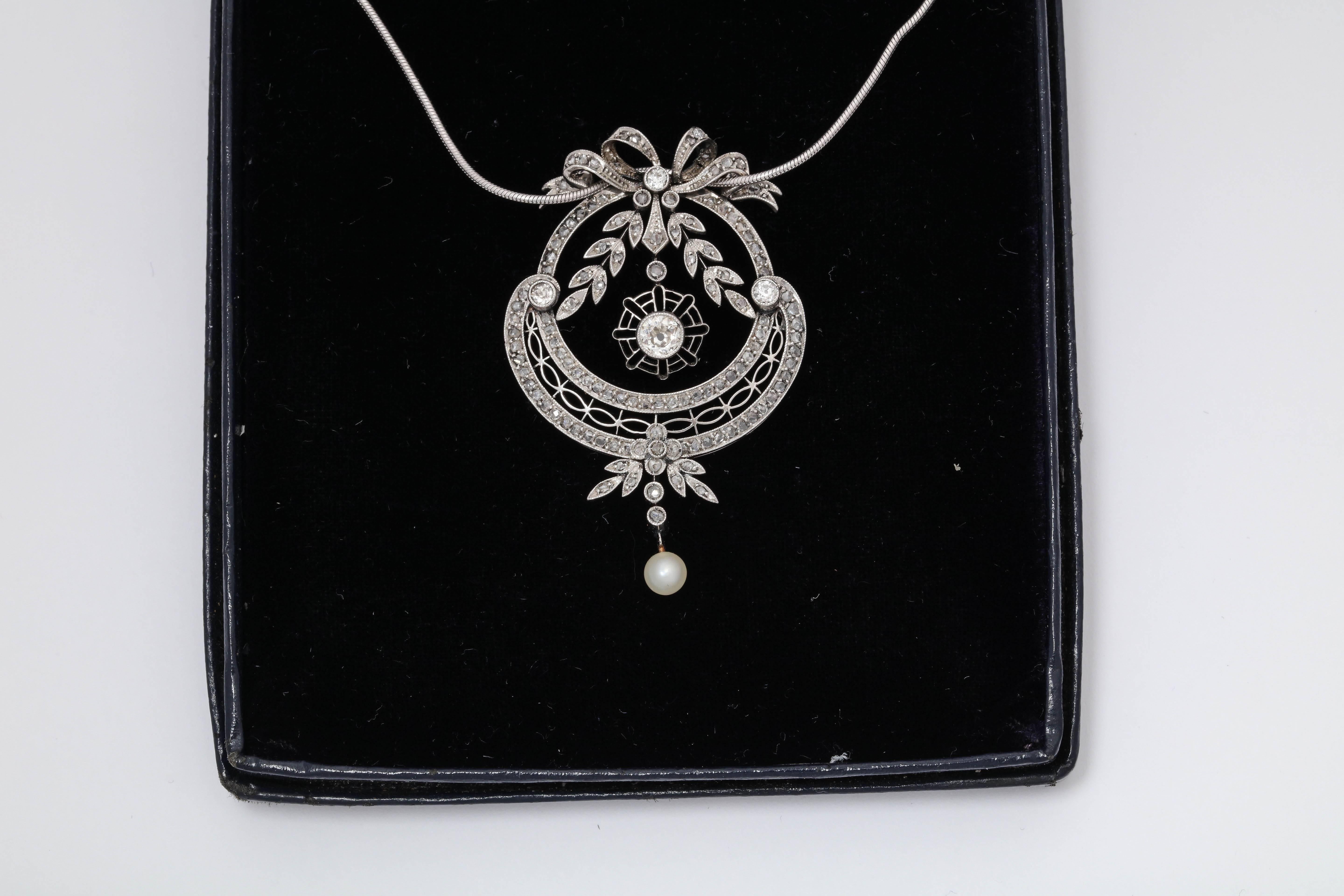 One Eduardian Pendant Drop Necklace Designed With Numerous Old Cut Antique Diamonds Weighing Approximately 1.50 Cts Total Weight. Pendant Is Created In A Handmade Reticulated Open Workmanship Type Of Setting With A Bow On The Top .Center Diamond