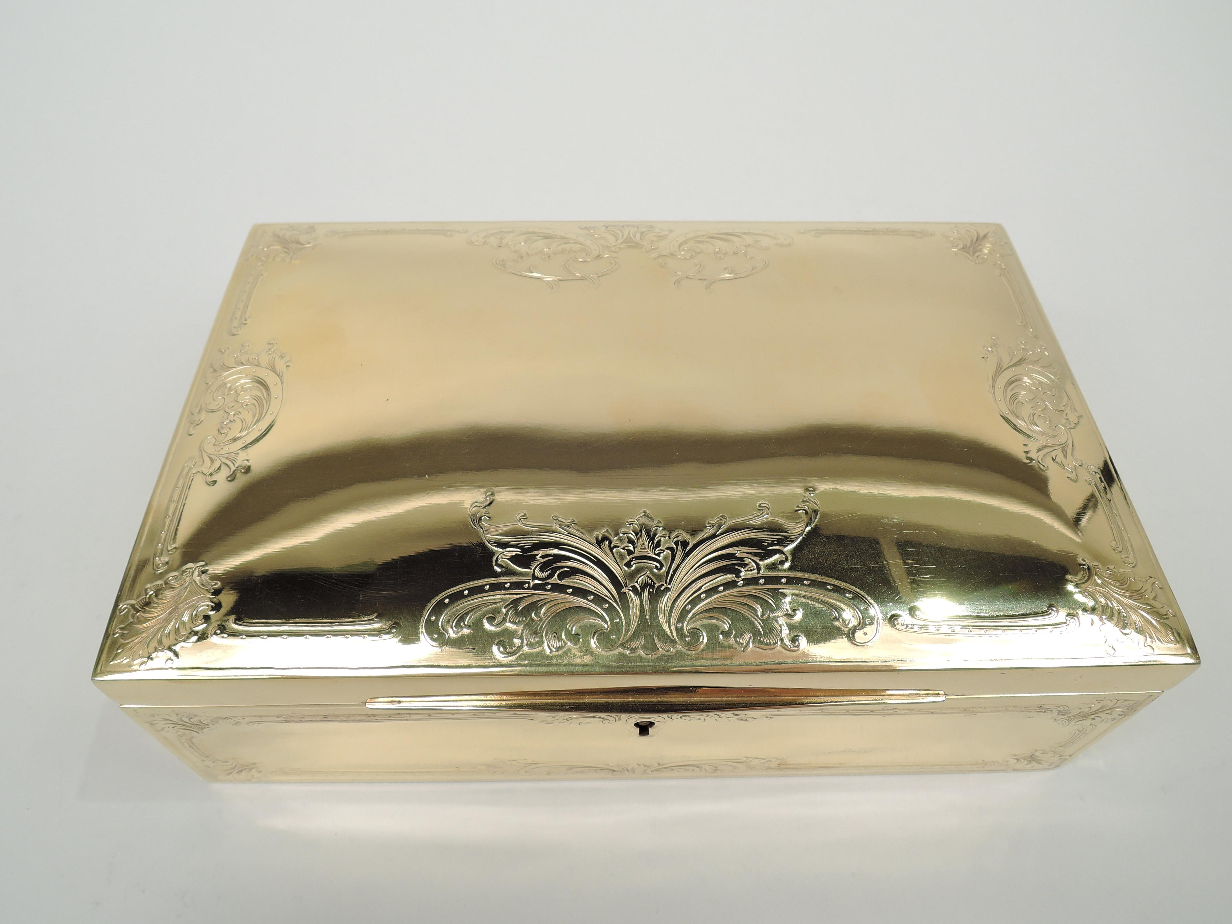 Edwardian classical gilt sterling silver jewelry box. Made by Ahrendt & Kautzman in Newark, ca 1910. Rectangular with straight sides. Cover hinged with tapering tab; top gently curved with acid-etched leafing scroll border. Velvet-lined interior.
