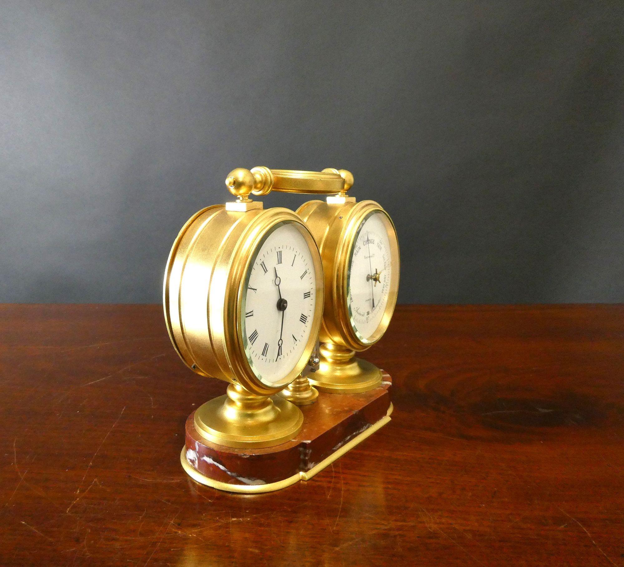 Housed in a gilded case standing on a raised, moulded rouge marble base with brass banding surmounted by a decorative gilded carrying handle.
The clock to the left with enamel dial, Roman numerals, original ‘blued’ steel hands. Eight day French