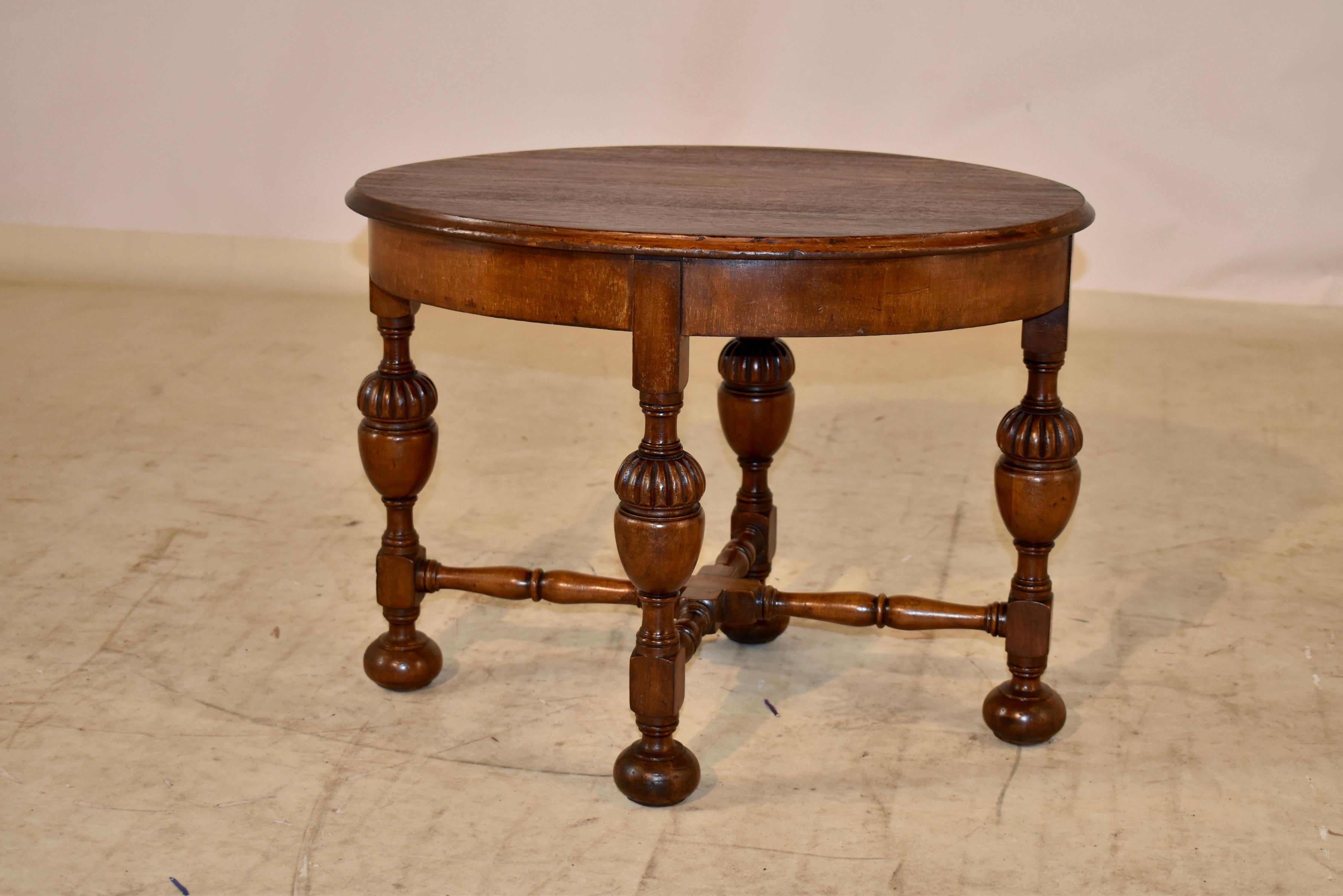 Edwardian walnut small cocktail/coffee table from England. The top has lovely graining and a beveled edge over a simple apron. The table is a lovely oval shape and is supported on hand turned legs with bulbous turnings for added design interest. The