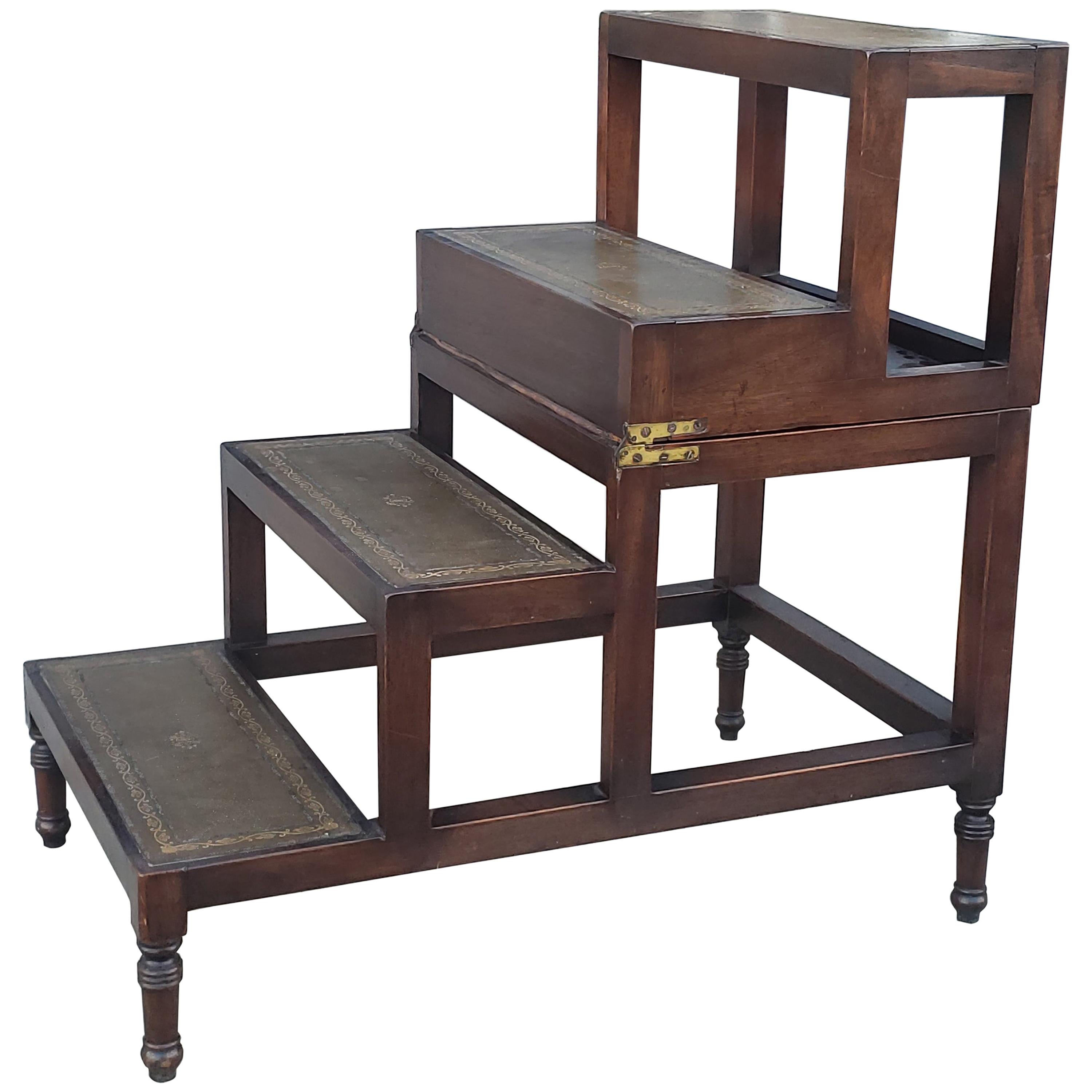 A George III design, mahogany four-step metamorphic library coffee table, with a naturally aged decorative gilt incised leather top and leathered steps opening to form a library step ladder on brass castors. Measurements are as stairs, table height