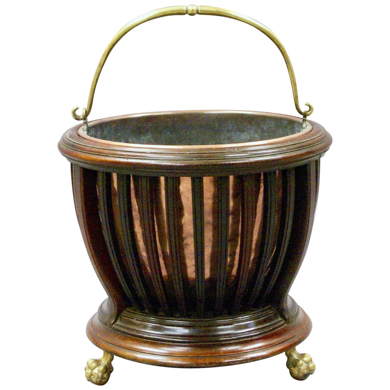 This very attractive Edwardian mahogany bucket features a slatted body design to show a polished copper liner with a brass handle. The bucket stands on brass ball and claw feet and bears the maker’s name ‘Raleigh’ with the registered design number