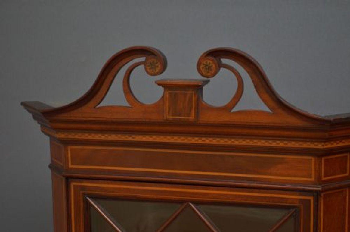 Sn4559 Edwardian mahogany and inlaid wall hanging wall cabinet, having inlaid swan neck pediment, astragal glazed door fitted with original working lock and a key and enclosing 2 shelves, all flanked by inlaid pilasters.
This antique cabinet retains
