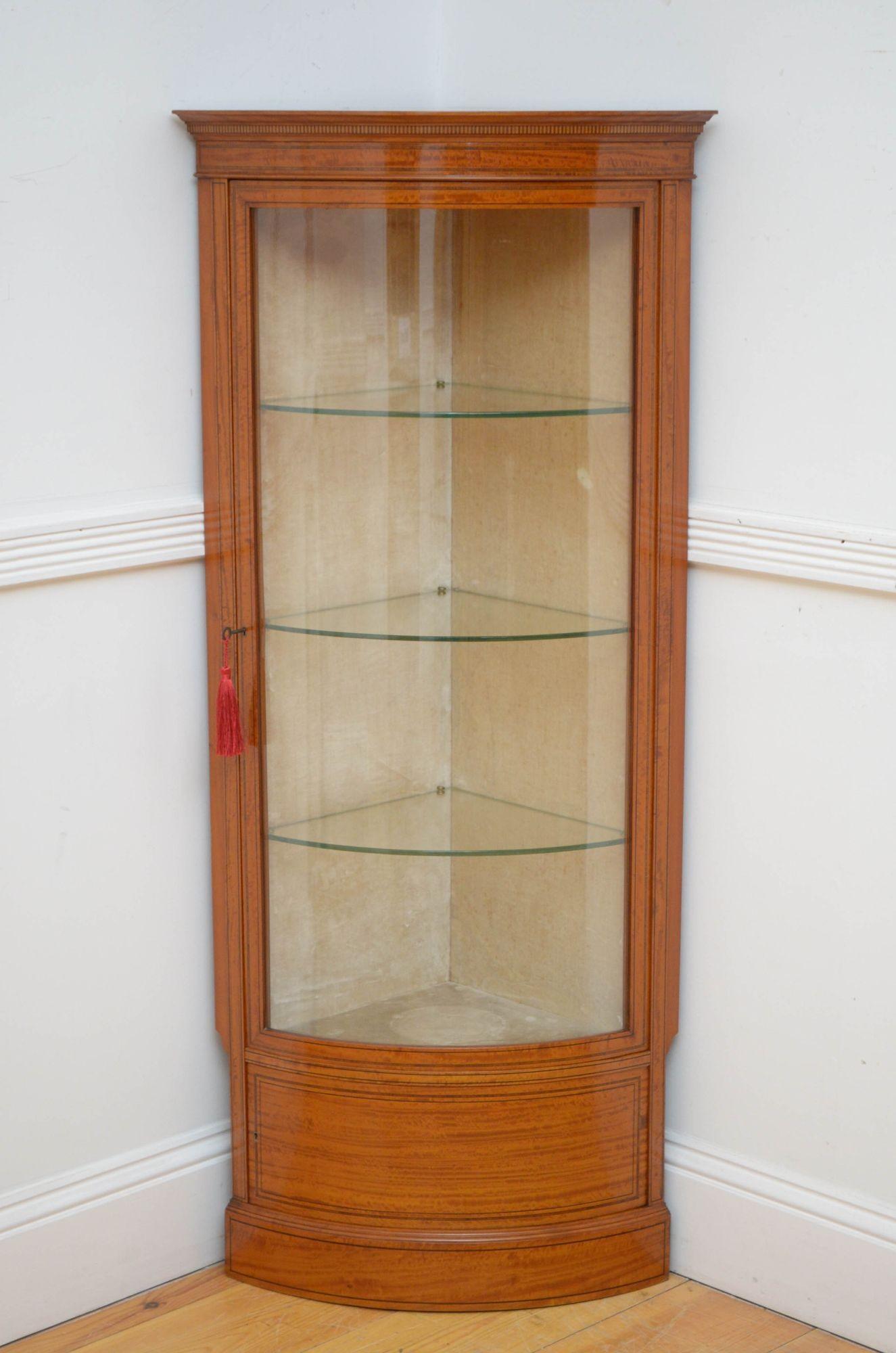 Sn5319 Stylish and very rare Edwardian satinwood corner display cabinet, having inlaid top above bow fronted door enclosing glass shelves and inlaid cupboard below, both fitted with original working locks and a key, standing on moulded plinth base.