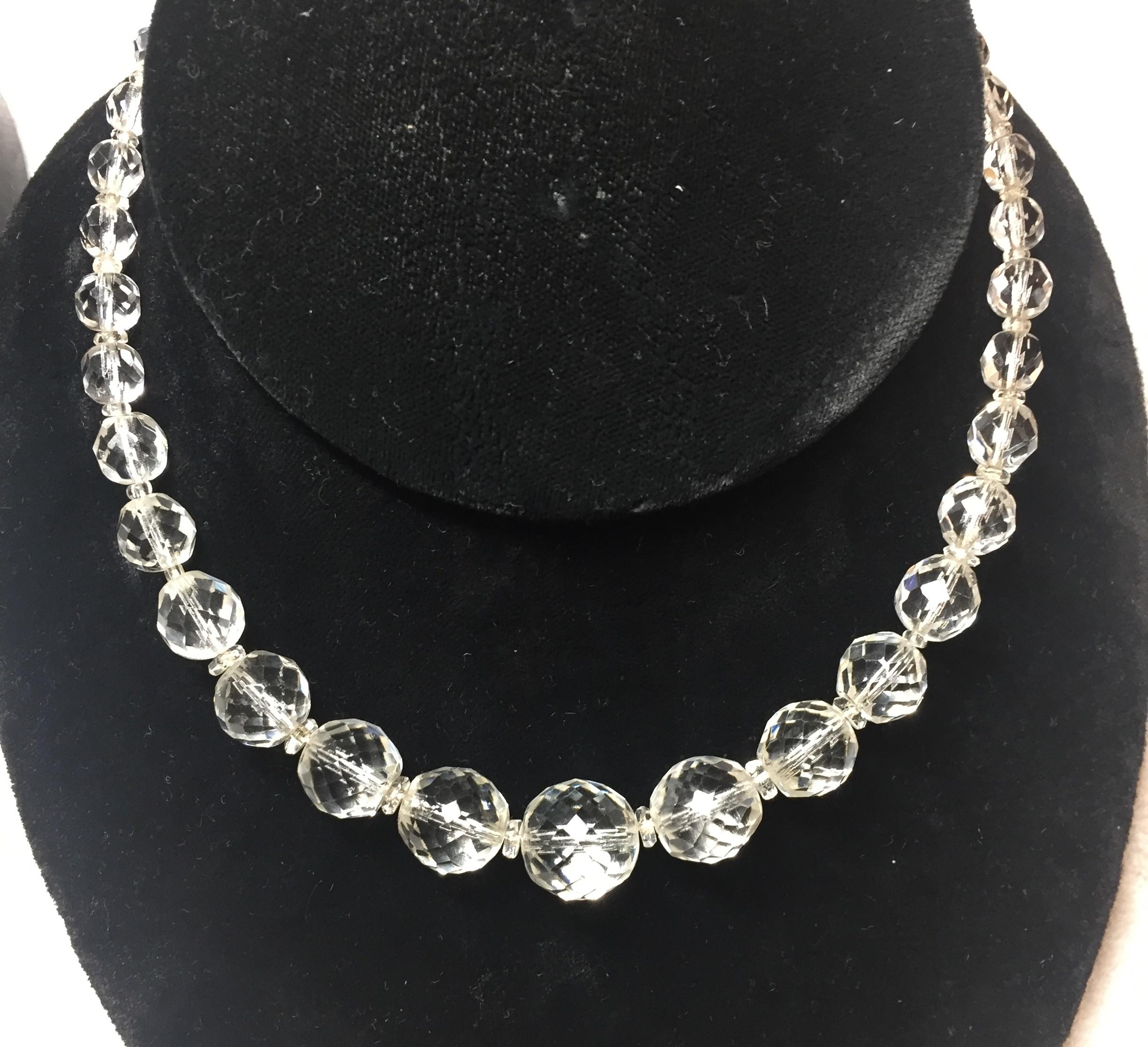 Offered here is an Edwardian cut lead crystal necklace and coordinating crystal & sterling screw-back earrings from the early 1900s. The highly-faceted crystals of the necklace are strung on silk cord, and graduate smoothly from 0.25