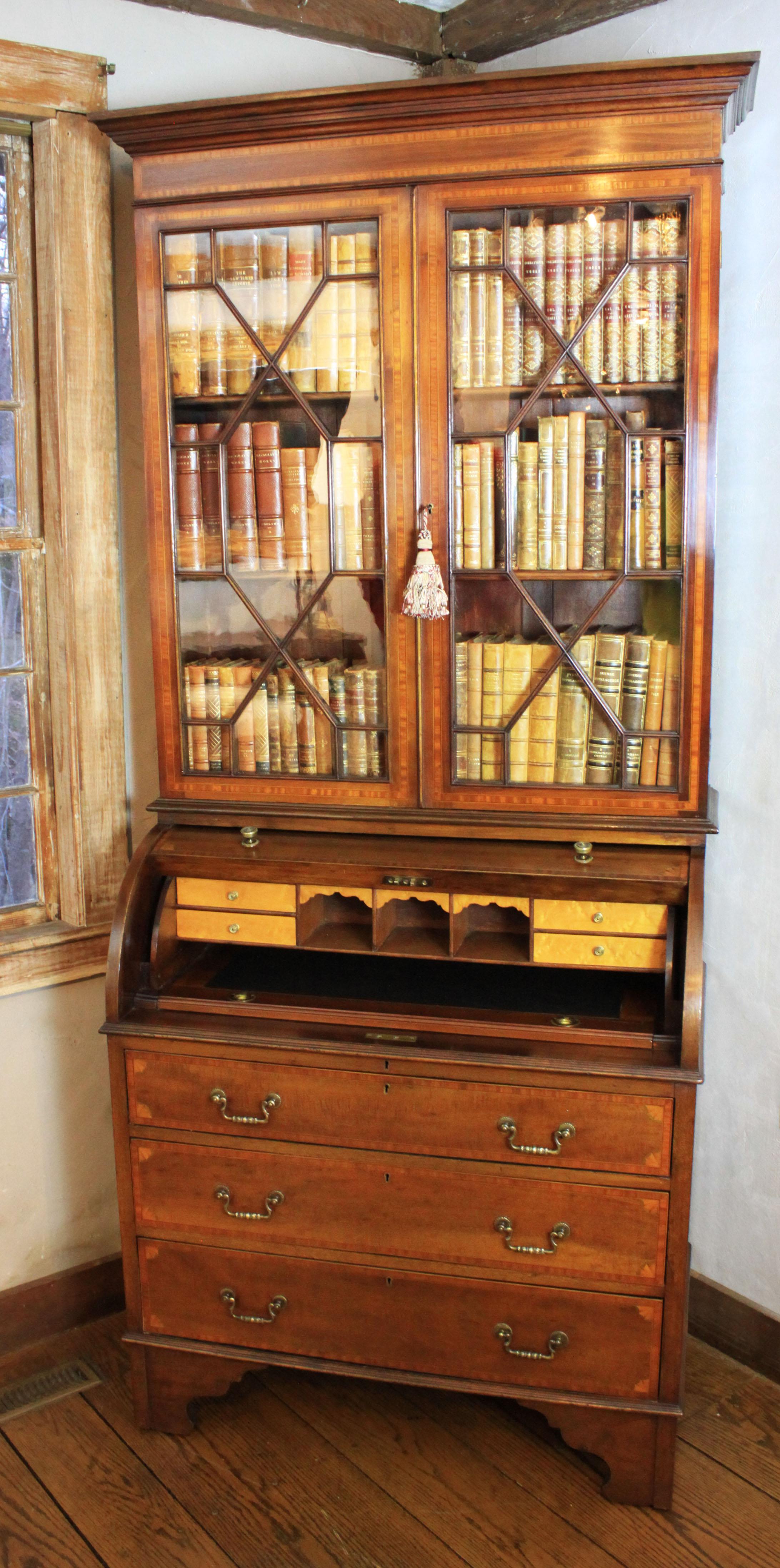 Inlaid Edwardian mahogany cylinder desk bookcase/secretary inlaid with satinwood, ebony and boxwood. Lower desk also includes fan inlays of satinwood and olive wood in the four corners of the cylinder fall and the three drawers. Interior features