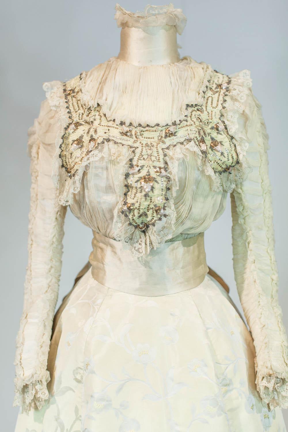 Circa 1895/1905
France 

Two-part ceremony nuptial dress (?), skirt and bodice, Japanese style dating from the Belle Epoque. High-waisted corset with a label woven on the waistband indicating Mademoiselle Tessier St Etienne. Cream satin background
