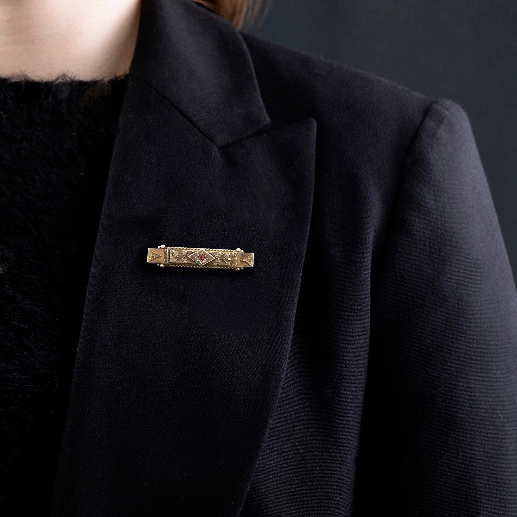 Broche barrettes de style édouardien avec une superposition d'or de couleur florale, un fil torsadé et un travail de granulation, sertie d'un petit doublet de grenats. La face avant est articulée et révèle un message secret 