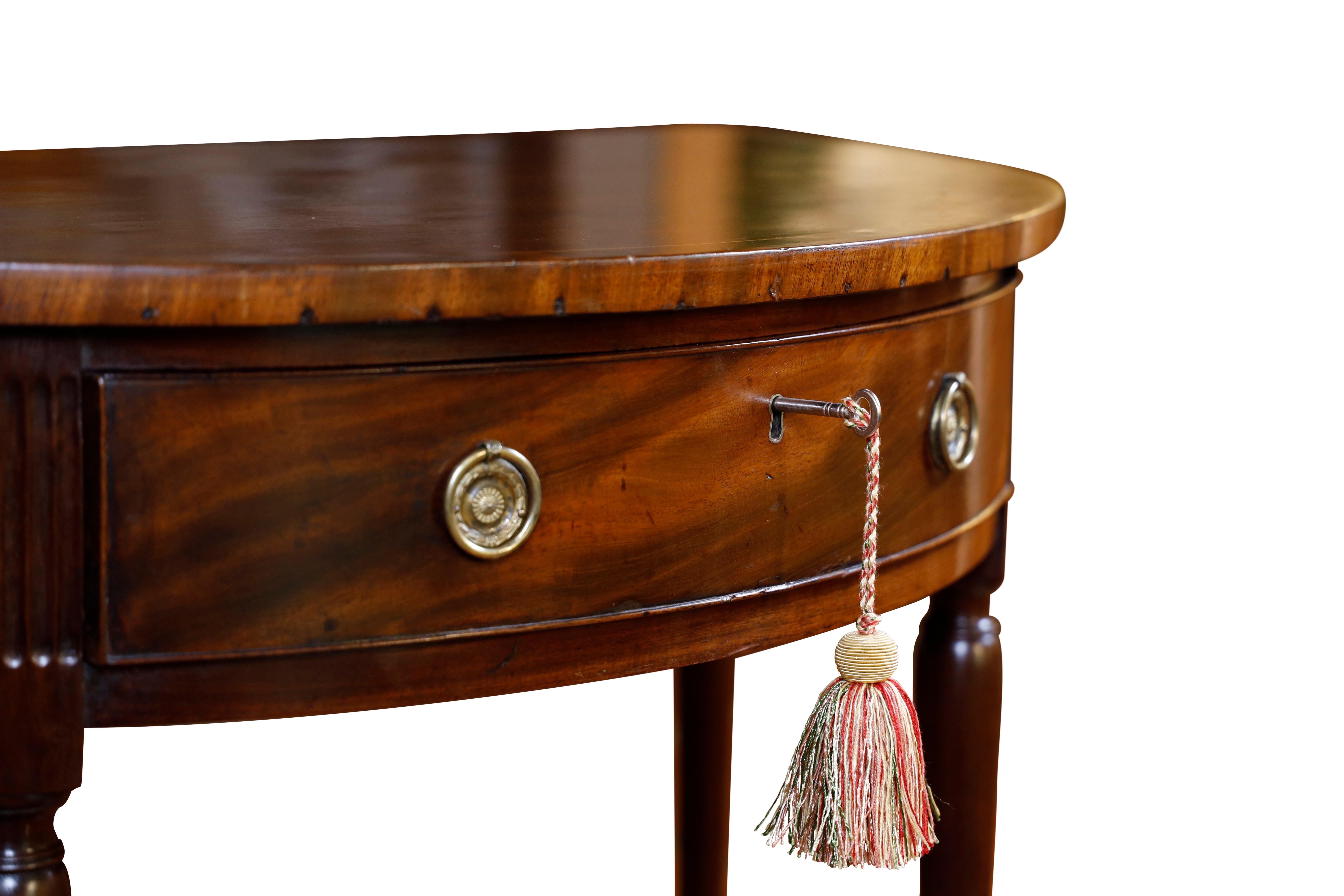 Georgian style mahogany demilune console table.  Top has mahogany crossbanding and satinwood string inlay.  Single oak lined drawer flanked by a cupboard door each side.  Table stands on turned legs.