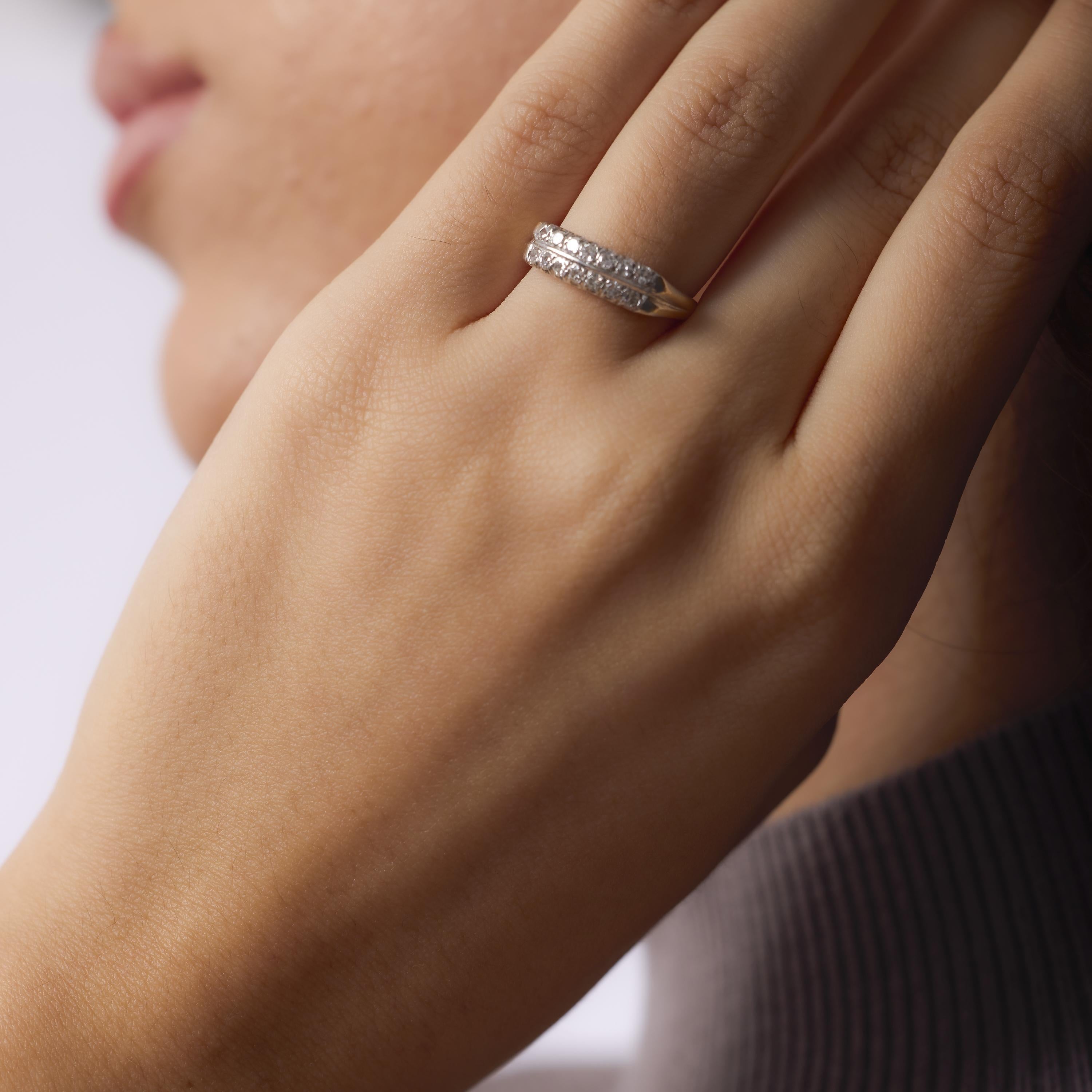This Edwardian wedding band is crafted in 14k yellow gold with a platinum top, set with fourteen single cut diamonds that offer soft, vintage sparkle. Created in the 1910s, its graceful design and delicate craftsmanship make it a refined symbol of
