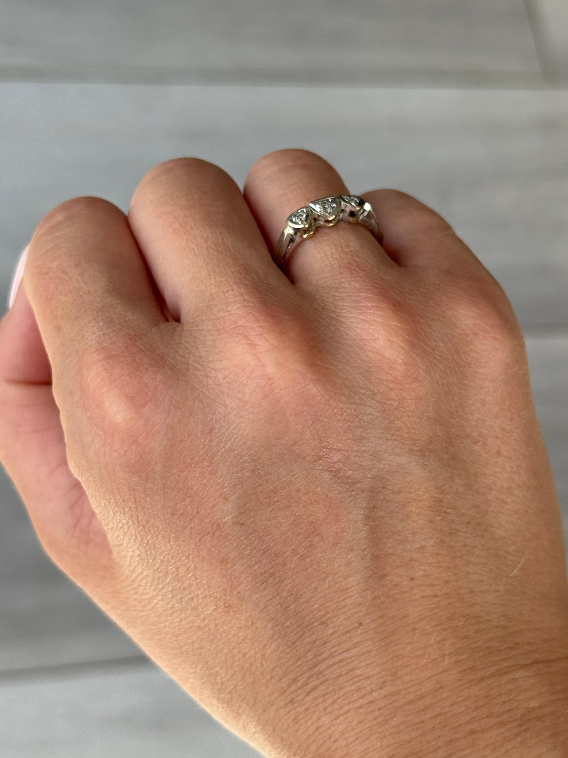 Questo anello è realizzato in oro 18 carati e le pietre sono incastonate in platino. Contiene tre diamanti incastonati a forma di cuore. I diamanti misurano 15pt. 

Misura dell'anello: K o 5 1/4 
Dimensioni della faccia: 13x5 mm 

Peso: 2,6 g