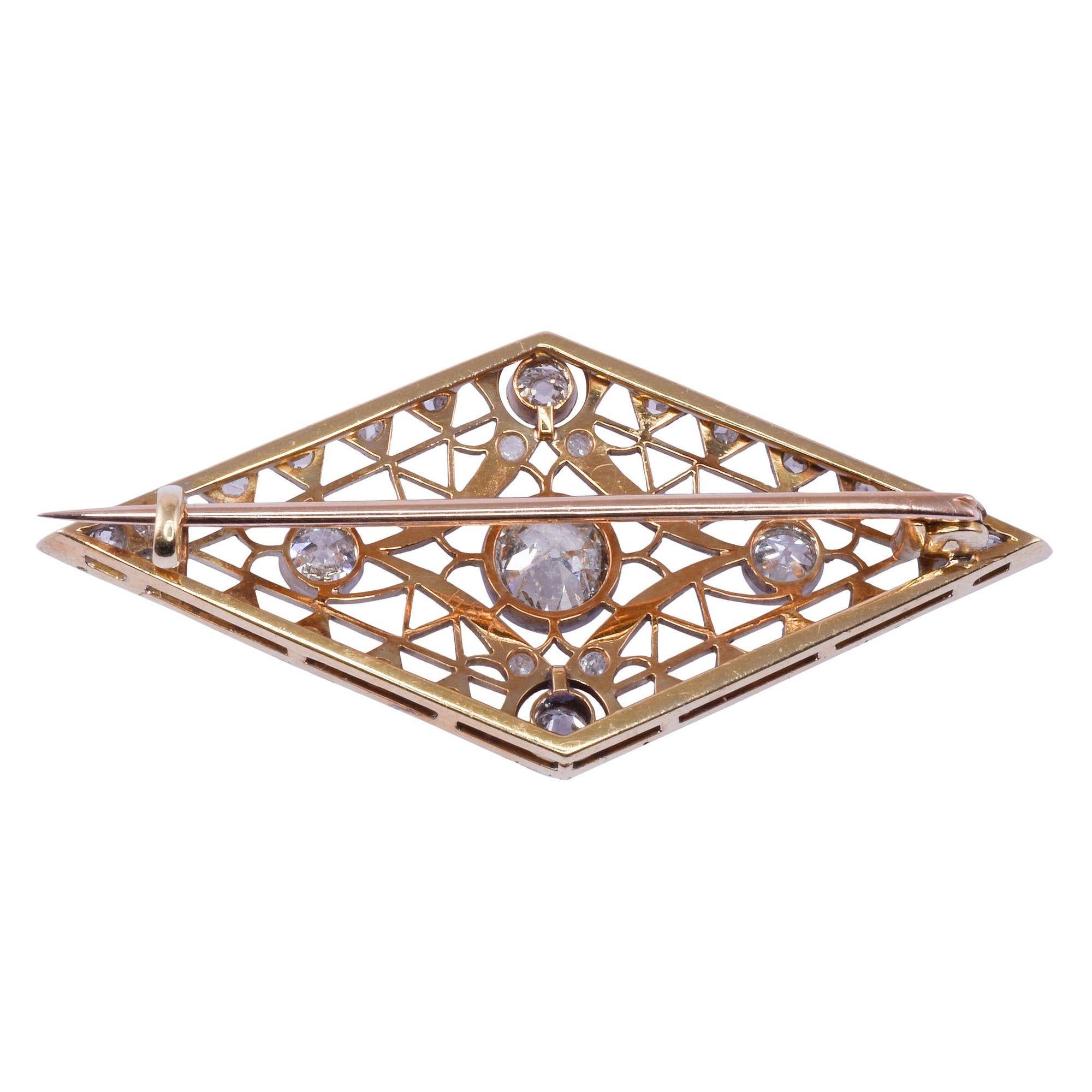 Antique Edwardian diamond 18K & platinum pin, circa 1910. This antique pin is crafted in 18 karat yellow gold and platinum. The lozenge shaped Edwardian pin features a .75 carat center diamond with I1 clarity and K color. There are also four old