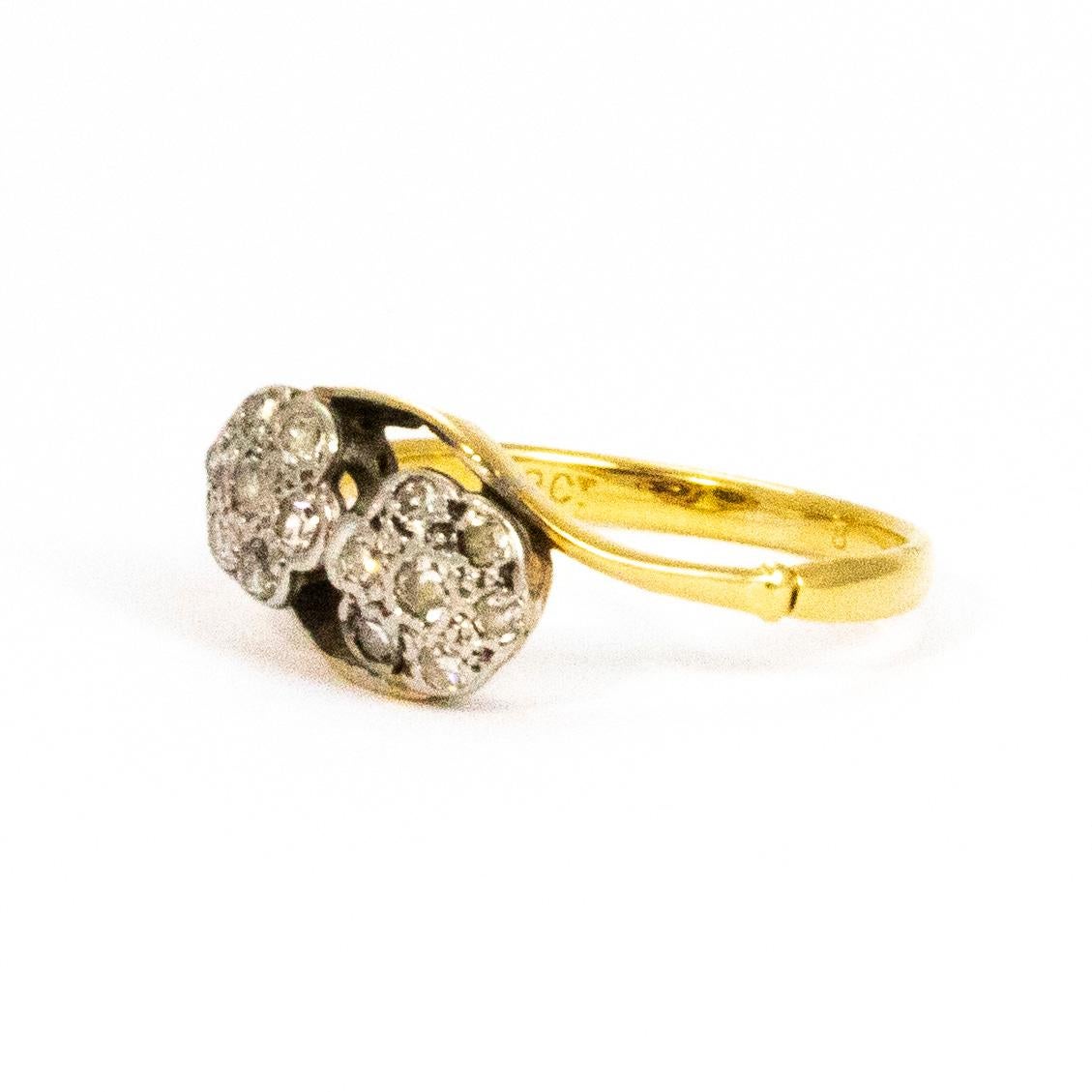 This wonderful double diamond cluster holds sparkling diamonds measuring 4pts each at the centre and around the centre stone the diamonds measure 3pts. The clusters are wonderfully twisted and the ring is modelled in 18ct gold and the stones set in