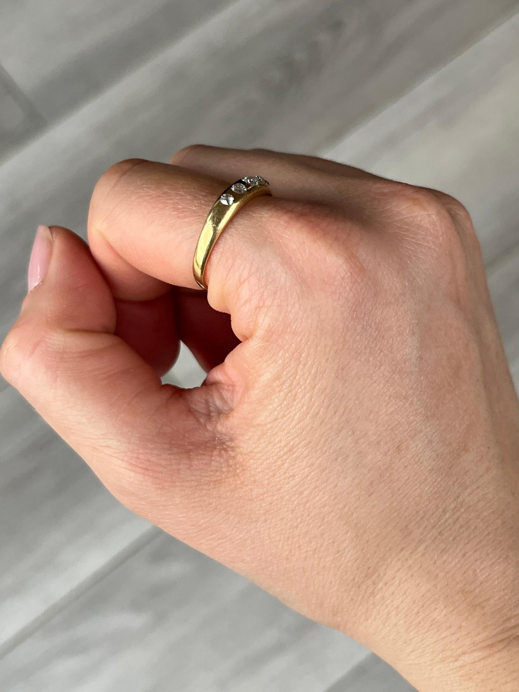 Set in this smooth 18carat gold band are five sparkling diamonds. The central diamond measures 10pts and the smaller diamonds measure 4pts. The diamond total of this ring is 28pts. Fully hallmarked Birmingham 1891. 

Ring Size: Q or 8 
Band Width: