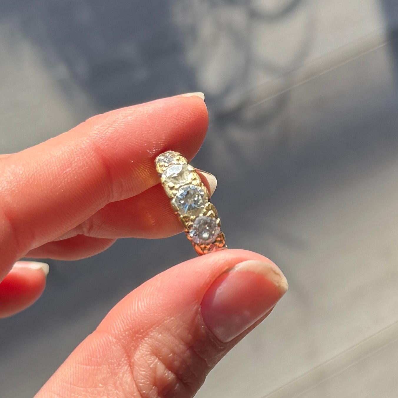 Set in this decorative 18carat gold rind are five diamonds. The central diamond measures 50pts and the smallest diamonds measure 15pts each. There is one stone with a large chip which is pictured. The diamond total is approx 1.5carats. 

Ring Size: