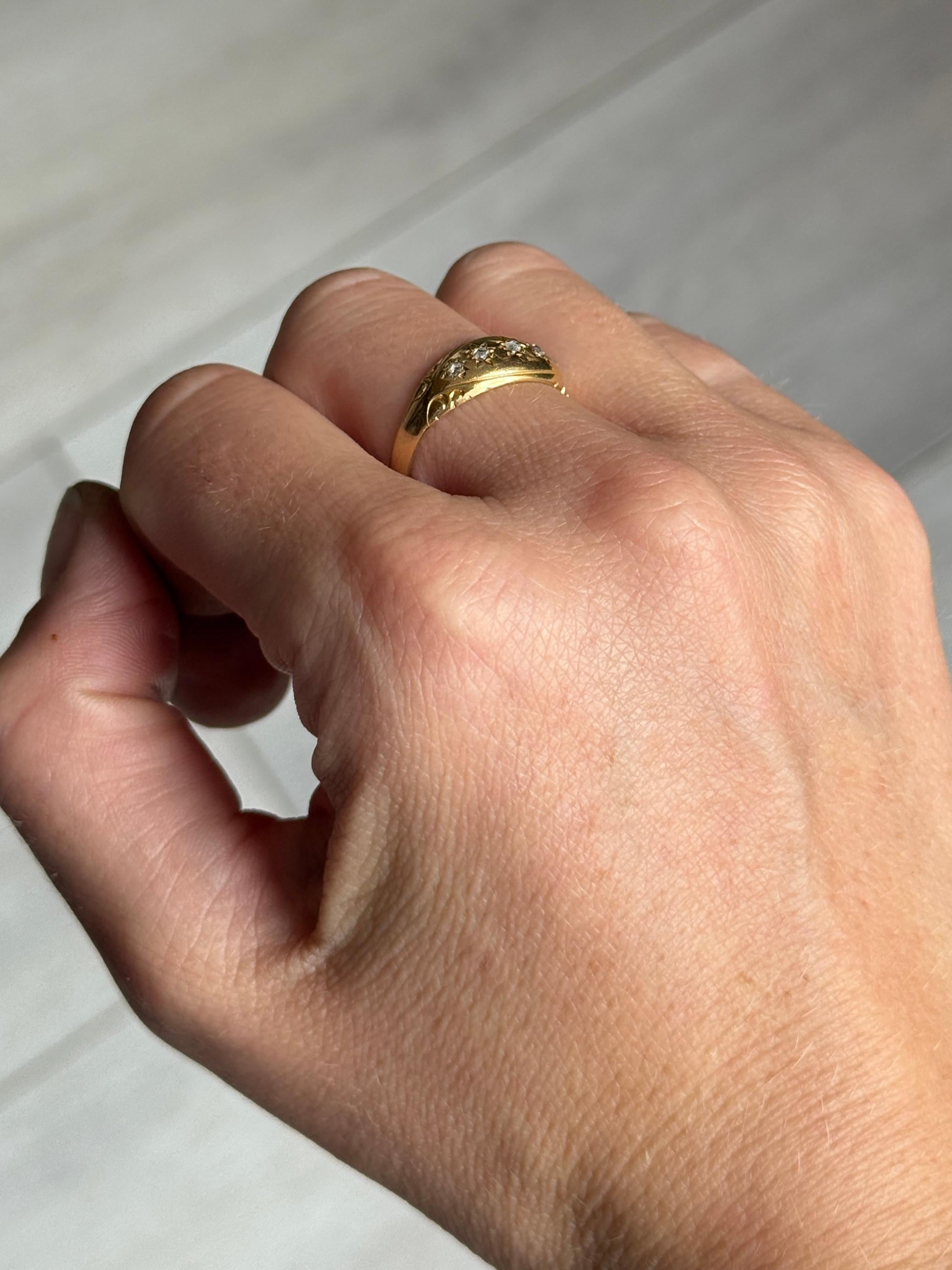 This gorgeous 18ct gold band holds five diamonds totalling 16pts with the central stone measuring 4pts. 

Ring Size: P 1/2 or 8
Band Width: 7.5mm 
Height Off Finger: 2mm

Weight: 3.4g