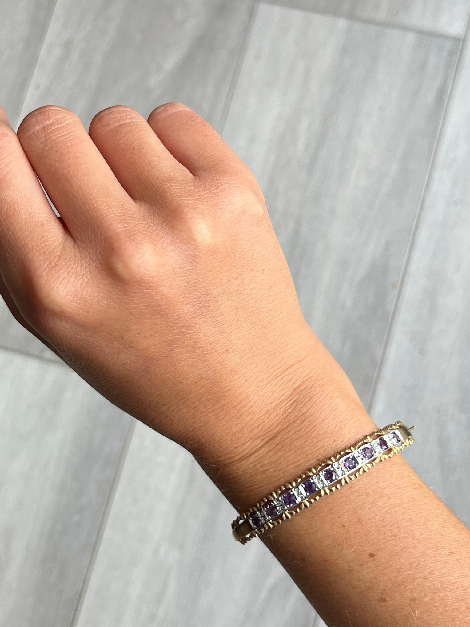 An exquisite antique bangle. Set with nine Amethyst stones which total 1.25ct. In between all f these gorgeous lilac stones are pairs of diamond points. All modelled in 9 carat yellow gold.

Diameter: 5.8cm (from hinge to clasp)
Front width: