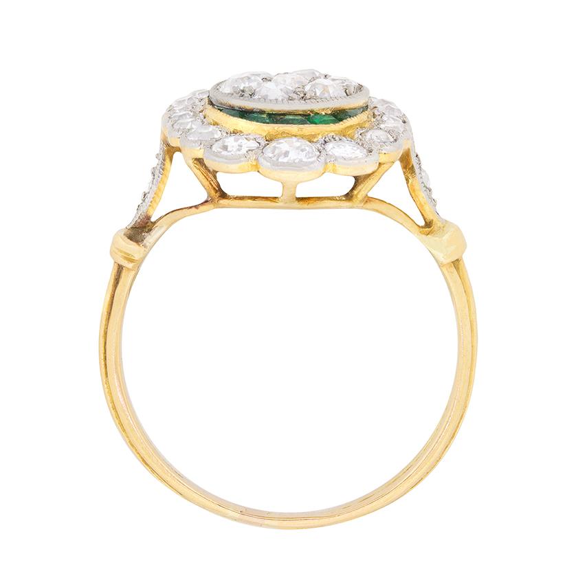 A wonderful dress ring with a stunning combination of diamonds and emeralds. The centre cluster of diamonds has a total weight of 0.40 carat and are round old cut diamonds. The outer halo, which is beautifully scalloped, has a total weight of 0.90