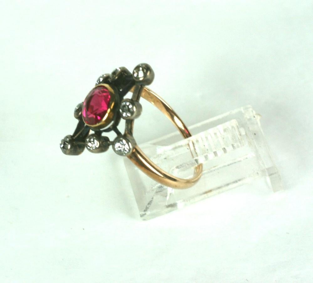Edwardian Diamond and Faux Ruby Ring circa 1900. A diamond shaped motif is set with knife edge collet set diamonds surrounding a large bezel set synthetic ruby. Period silver topped gold construction. Size 7.  1900 USA. 