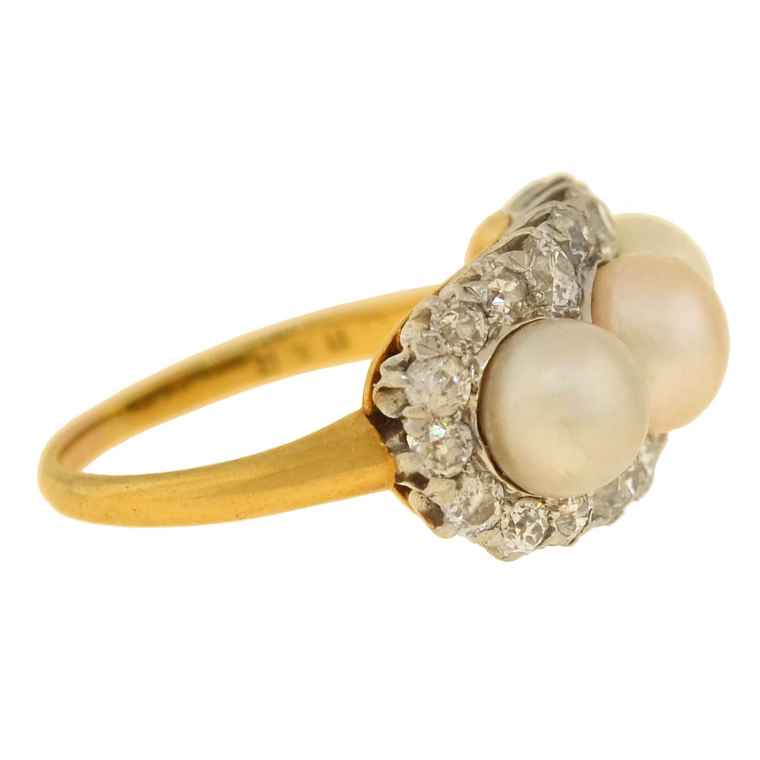 A stunning pearl and diamond ring from the Edwardian (ca1910) era! This fabulous ring is crafted in vibrant 18kt gold and topped in platinum for a stylish two-tone look. Resting in the center of the ring are three natural pearls, which are