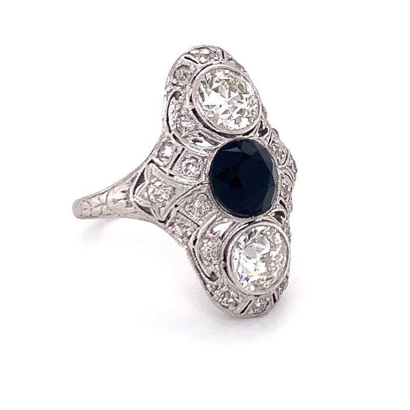Edwardian diamond and onyx filigree platinum ring centering one bezel set, round faceted black onyx measuring 6 millimeters in diameter along with two bezel set, old European cut diamonds weighing 0.85 ct. each. Also featuring 20 old mine cut