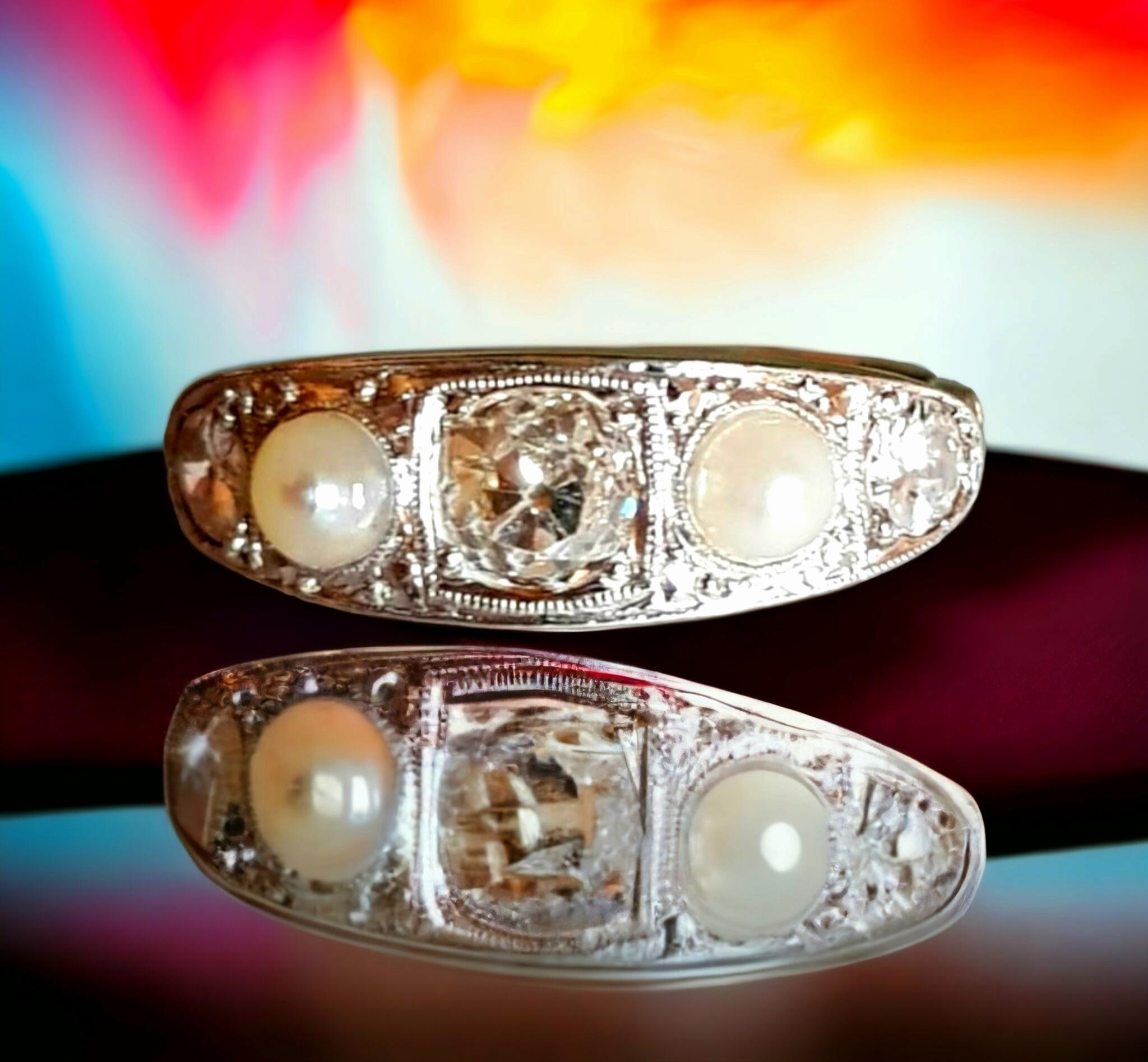 Original Edwardianischer Diamant- und Perlenring mit fünf Steinen in 18K Gold und Platin (1901-1915)

Er ist mit drei abgestuften Diamanten im Altminenschliff mit einem Gesamtgewicht von ca. über einem halben Karat und zwei Naturperlen gefasst. Die