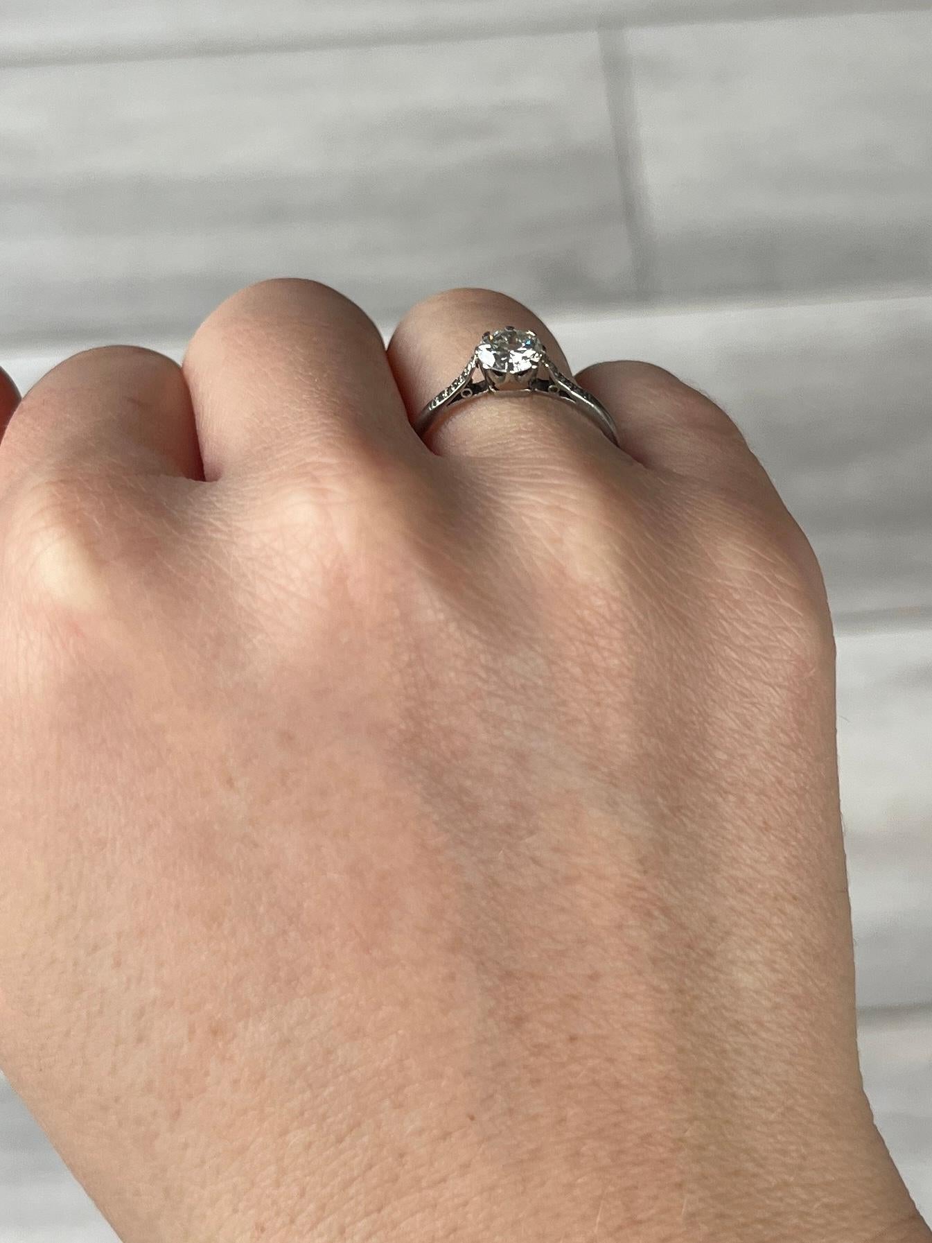 Ein Solitärring aus Platin mit altem europäischen Schliff. Der Diamant misst 80 Punkte und hat die Farbe J VS2. Die Verzierungen an den Schultern dieses Rings sind schlicht und klassisch mit Diamanten besetzt.

Ringgröße: N 1/2 oder 7
Höhe ohne