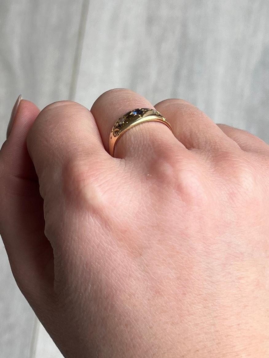 This gypsy ring holds a sapphire at the centre measuring approx 10pts, two rose cut diamonds measuring 3pts each and these are set in star settings. 

Ring Size: N or 6 3/4 
Band Width: 7mm

Weight: 2.5g