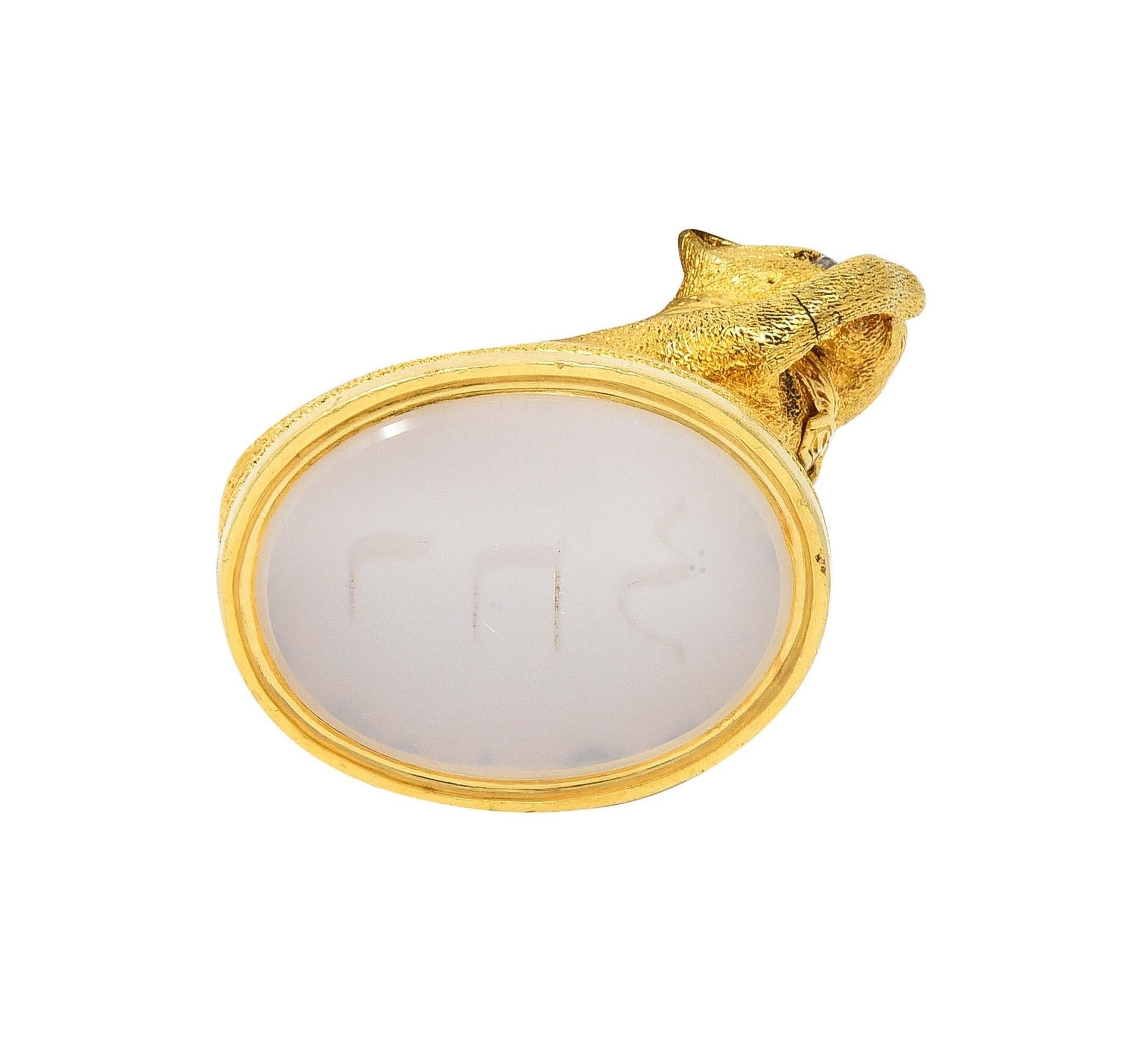 Designed as a highly rendered cat perched atop a cushion wearing a collar
Posed licking its paw and engraved with fur texture throughout body
Accented by flush set rose cut diamond eyes 
Weighing approximately 0.02 carat total - quality consistent