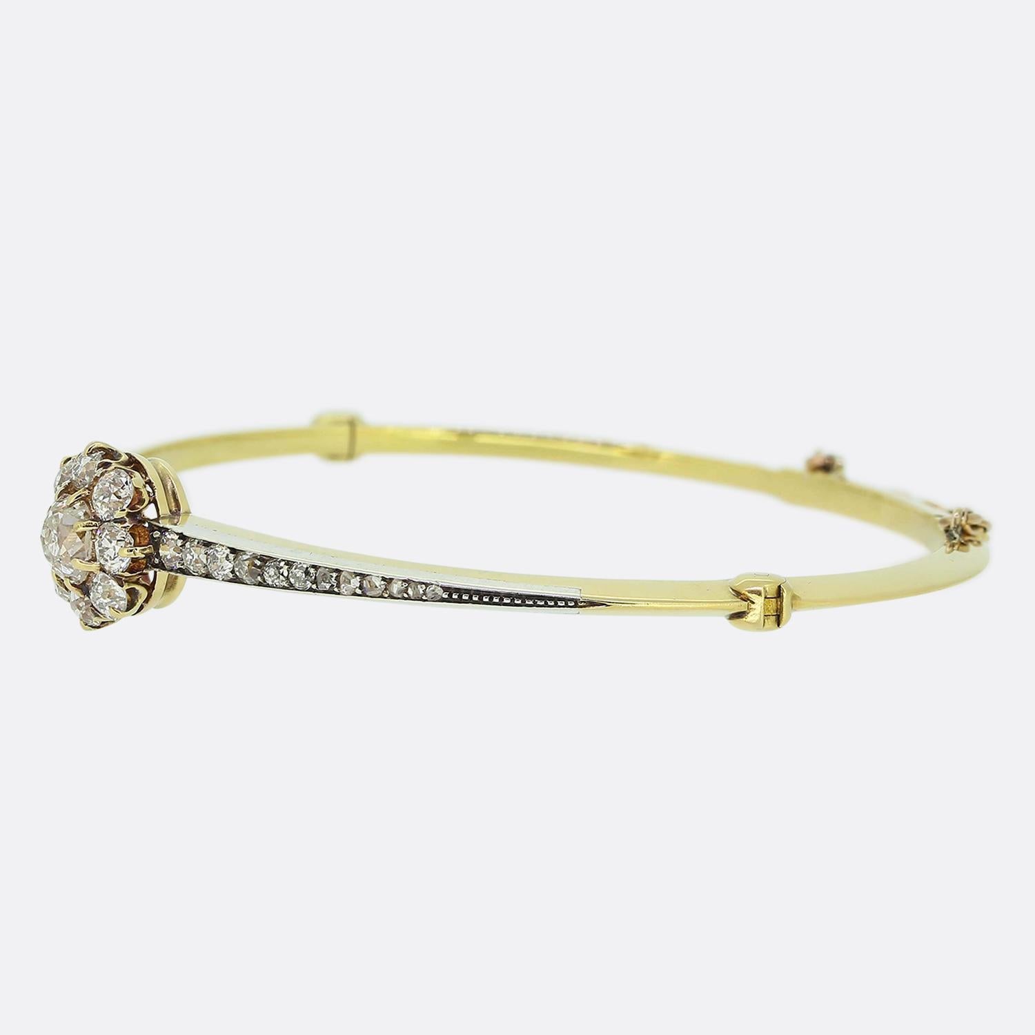 Here we have a sensational diamond bangle taken from the Edwardian era. This antique piece has been crafted from 18ct yellow gold and features a sleek knife edge band which neatly wraps around the wrist. This elegant design plays host to a focal