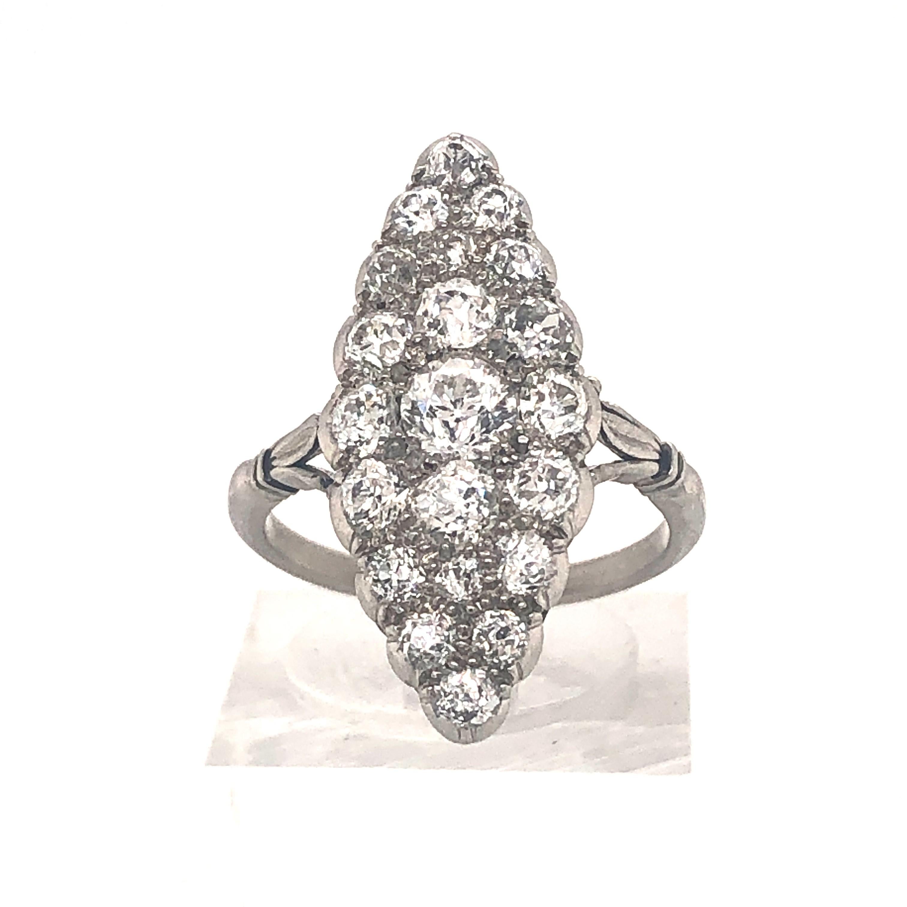 An Edwardian diamond cluster ring, marquise shaped design, with twenty-one, pavé set, old cut diamonds, mounted in platinum with carved detail to the shoulders and a carved gallery, with an estimated total diamond weight of 1.50ct, estimated colour