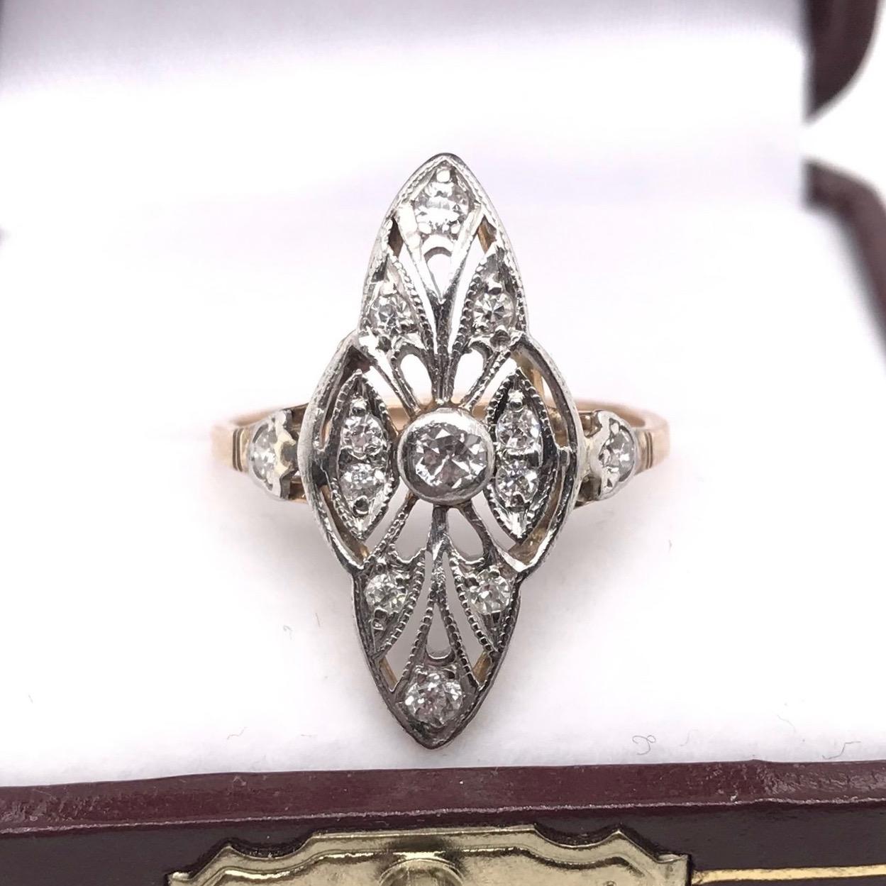 This antique piece was handcrafted sometime during the Edwardian design period ( 1900-1920 ). The setting is 10k gold and features 13 sparkling diamond accents. The setting features subtle milgrain accents as well as white gold accents. This is a