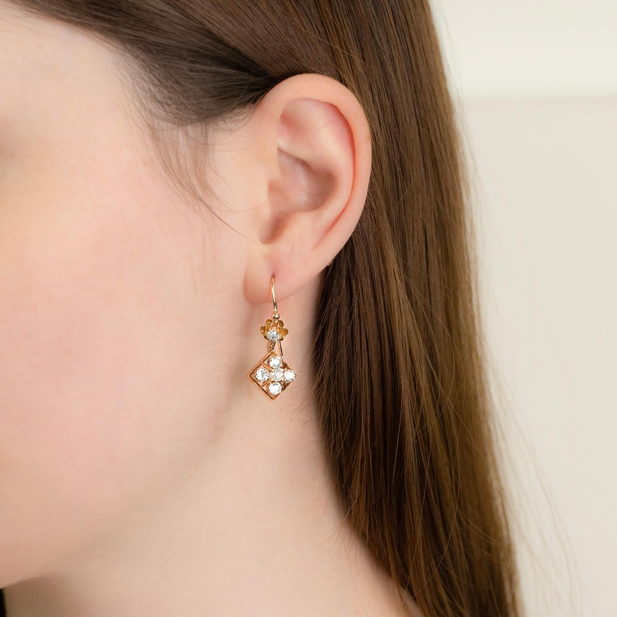 One pair of drop earrings and each set with six old mine cut diamonds. Crafted in all yellow gold with a scalloped diamond set scalloped setting and shepherd hook to a knife-edged box setting earrings. This pair of earrings were constructed by