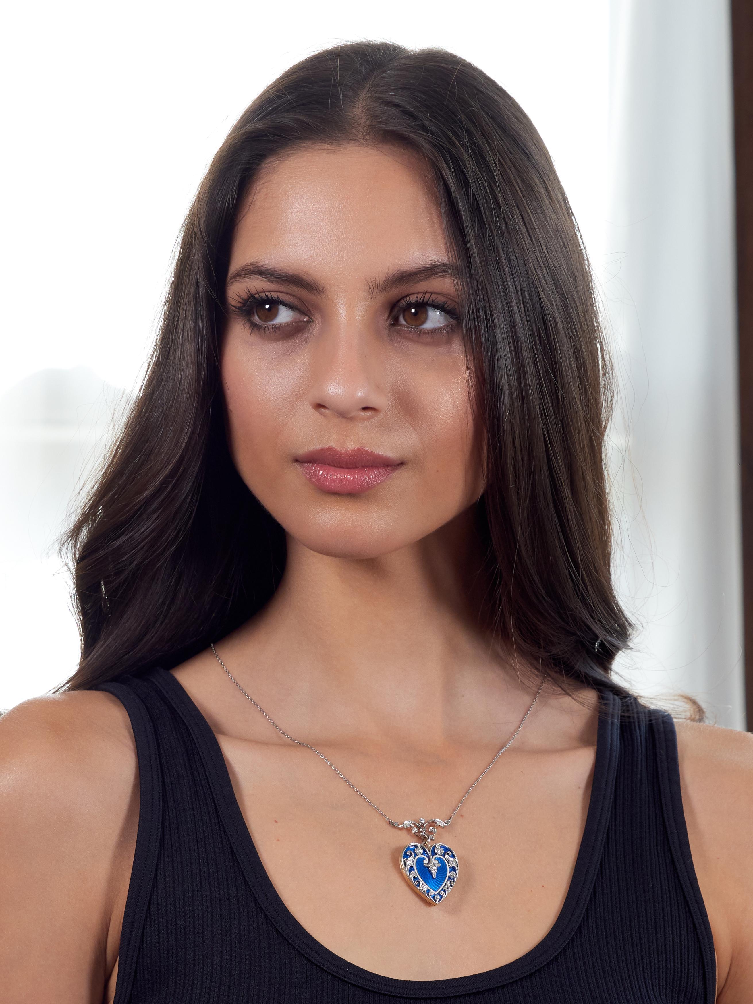 Comprised of a cable link chain suspending a heart pendant from a fleur-de-lis motif surmount station
Surmount and locket are decorated with platinum scrolling foliate motif bead set with diamonds
Old European cut and weighing approximately 0.65